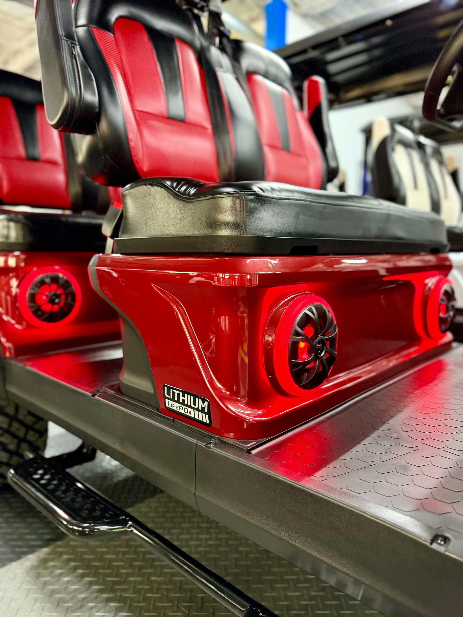 A golf cart with red and black seats and speakers