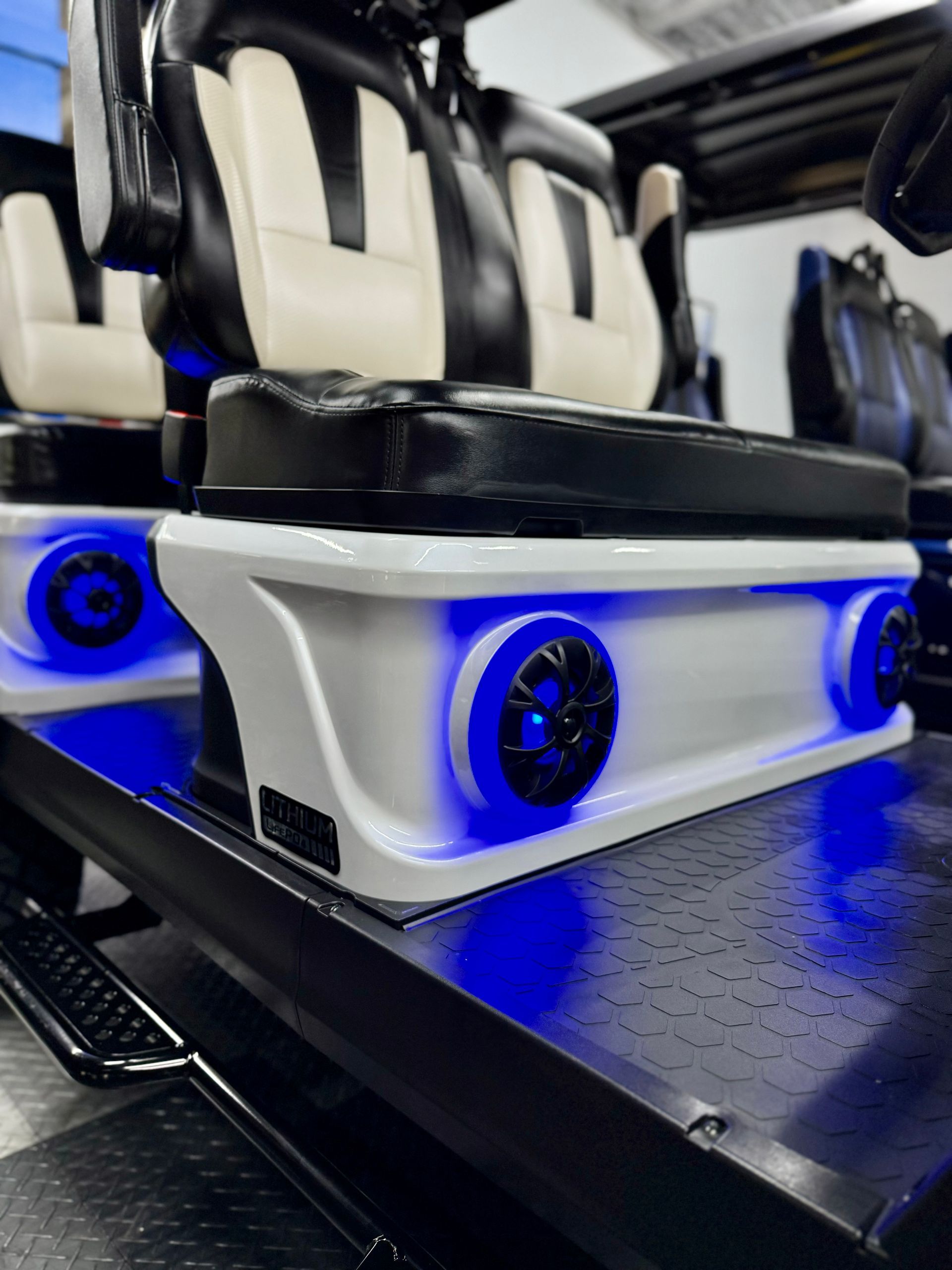 A close up of a golf cart with speakers and blue lights.
