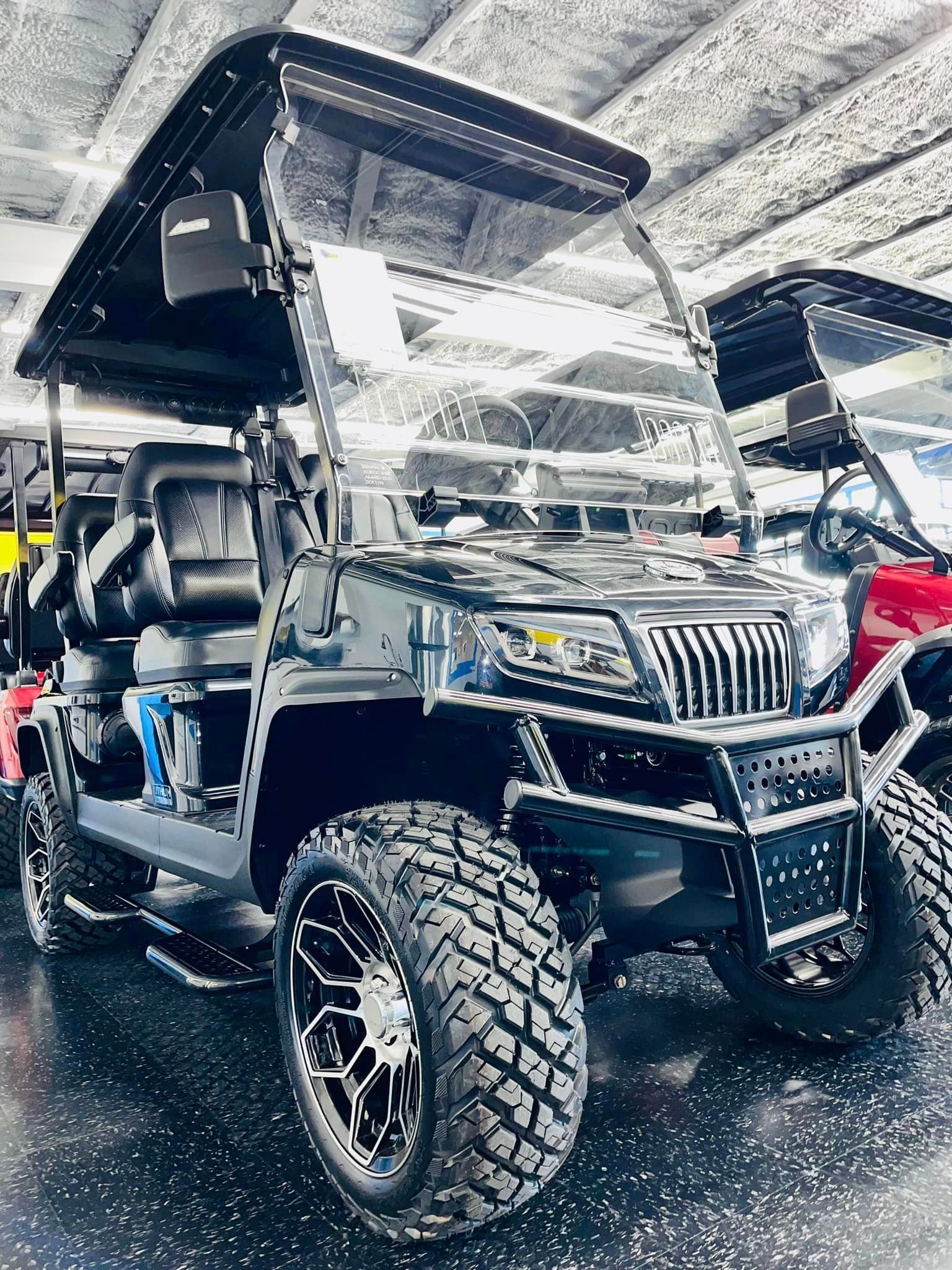 A black golf cart is parked in a garage.