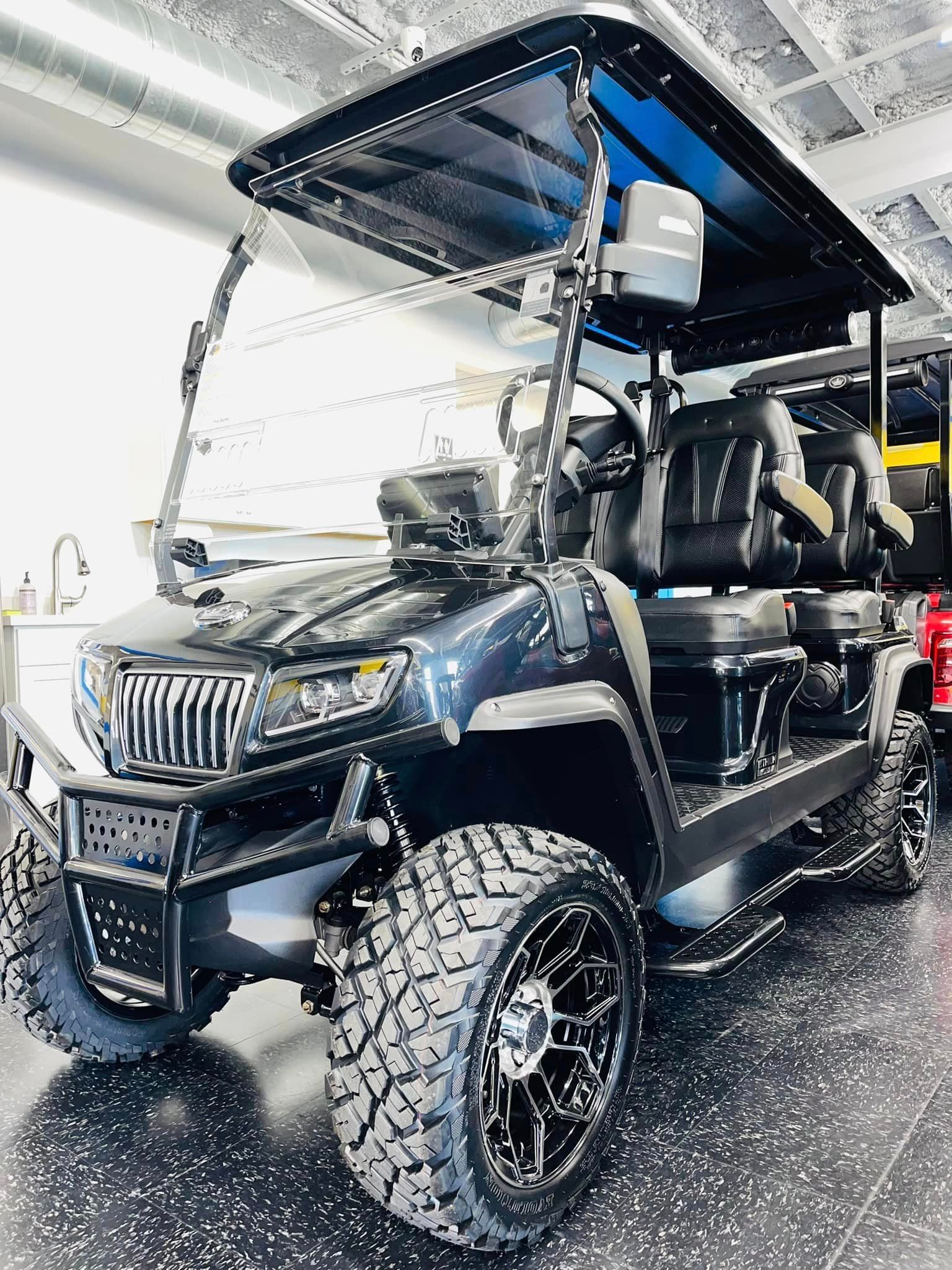 A black golf cart is parked in a garage.