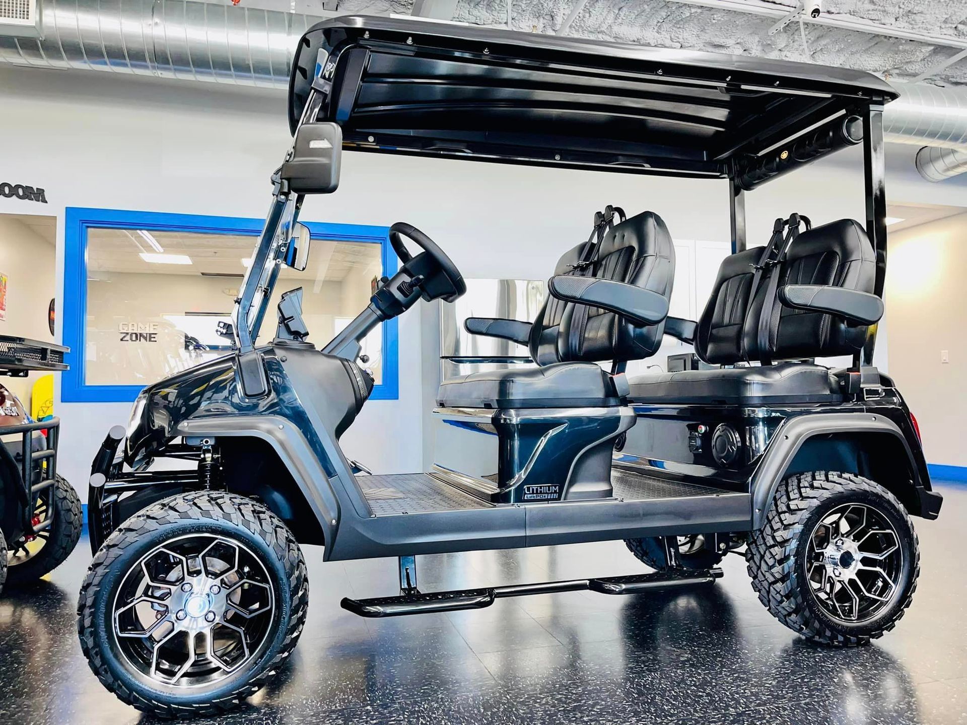 A black golf cart is parked in a garage.
