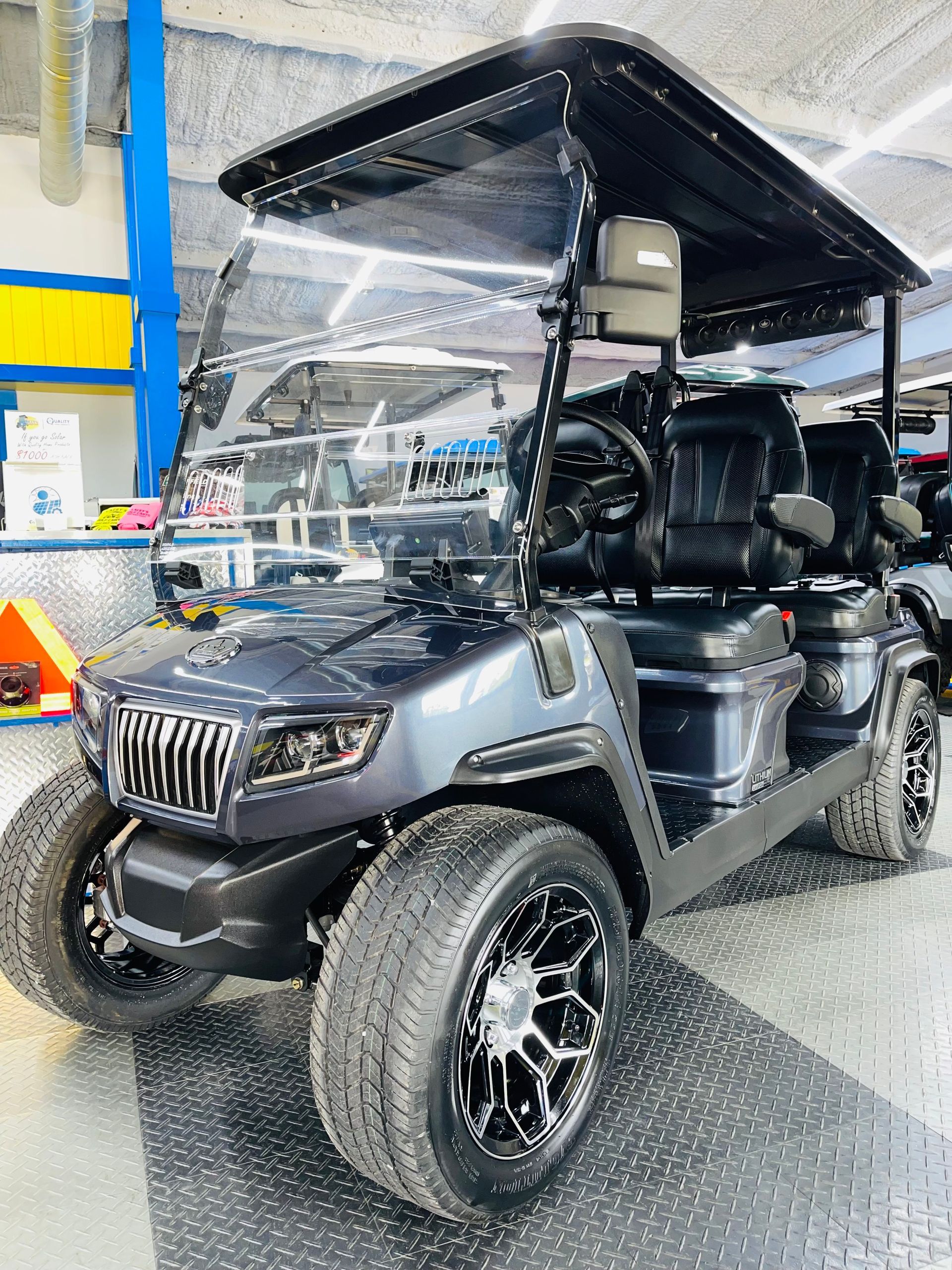 A black golf cart is parked in a garage.