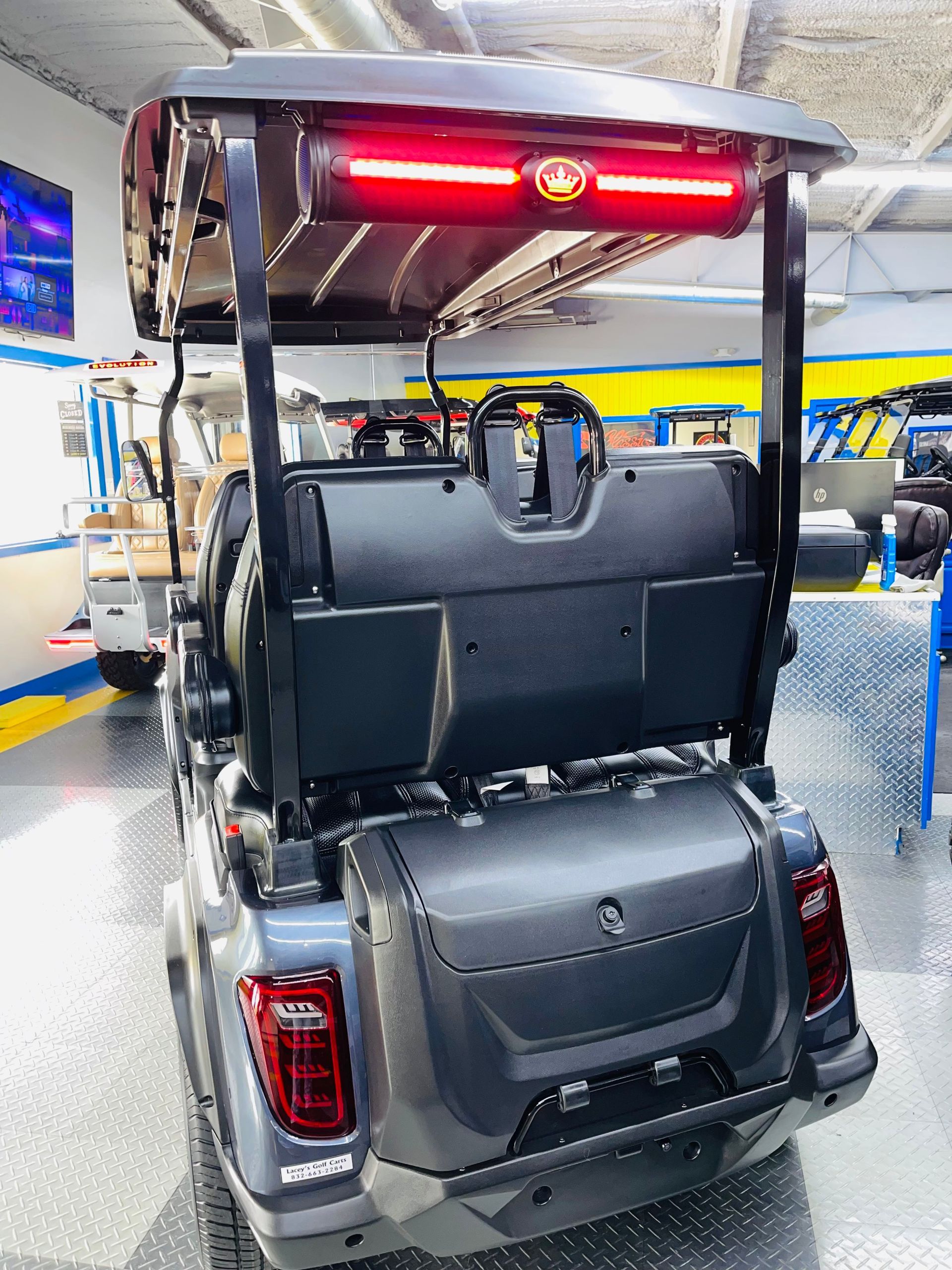 A golf cart is parked in a garage with a red light on the back.