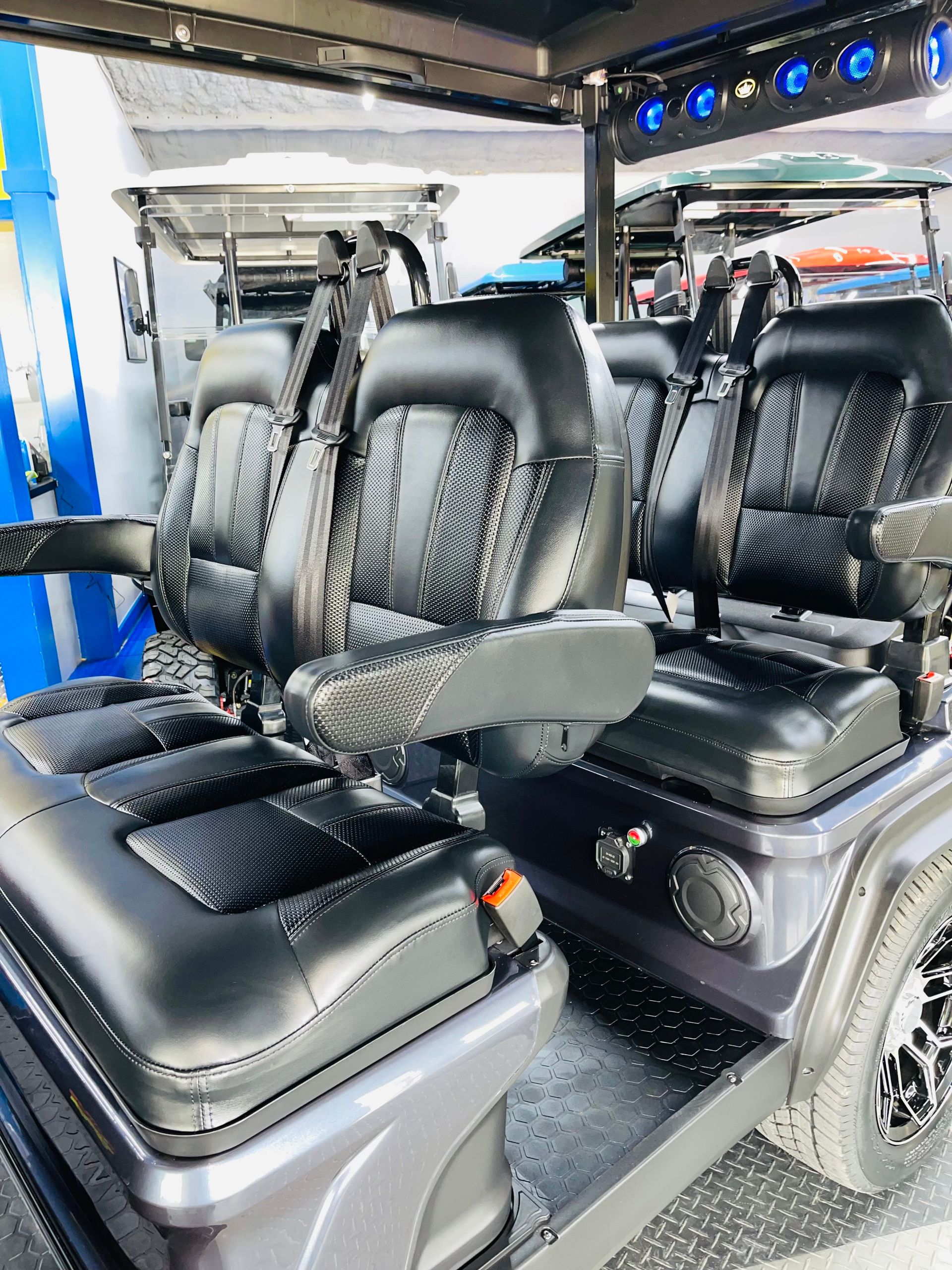 A golf cart with four seats is parked in a garage.