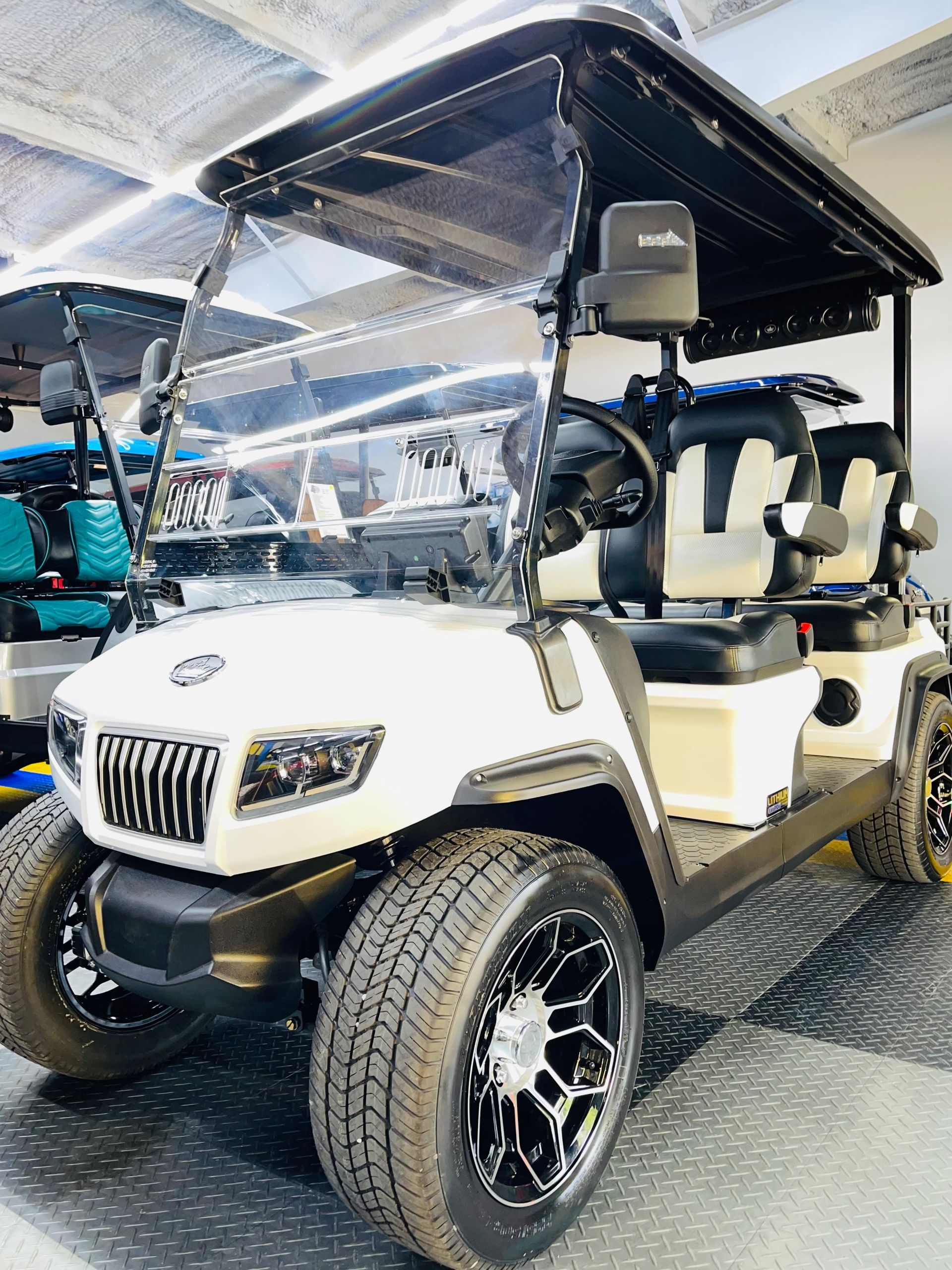 A white golf cart is parked in a garage.