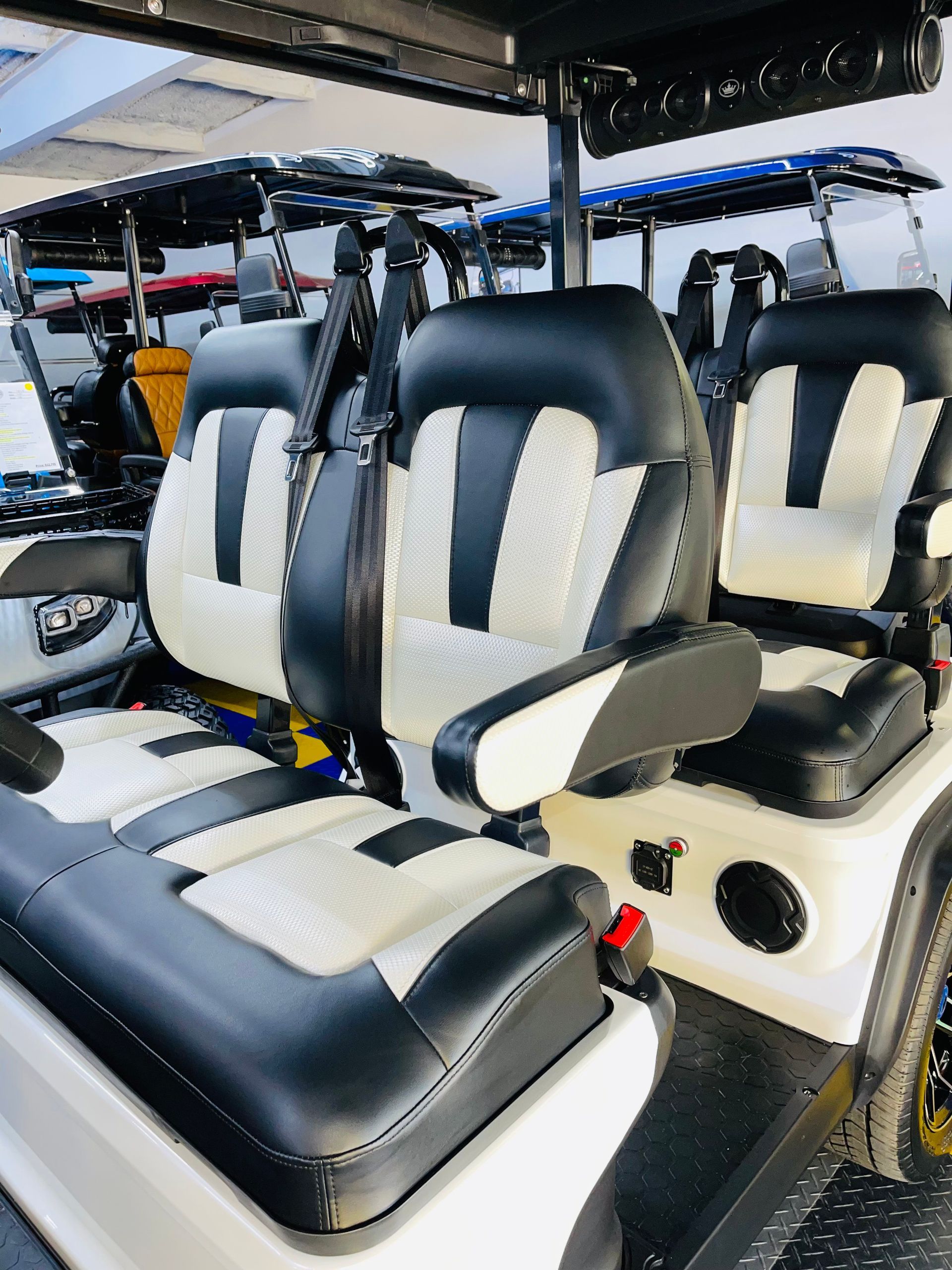 The inside of a golf cart with black and white seats