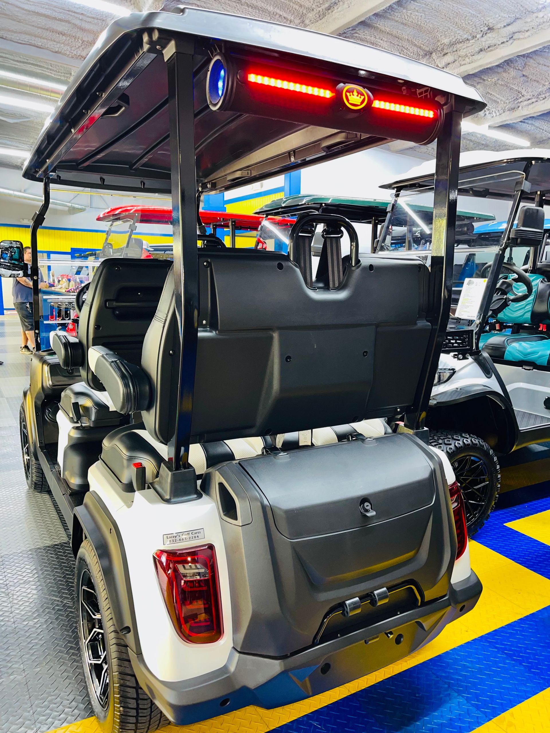 A golf cart is parked in a parking lot with the trunk open.