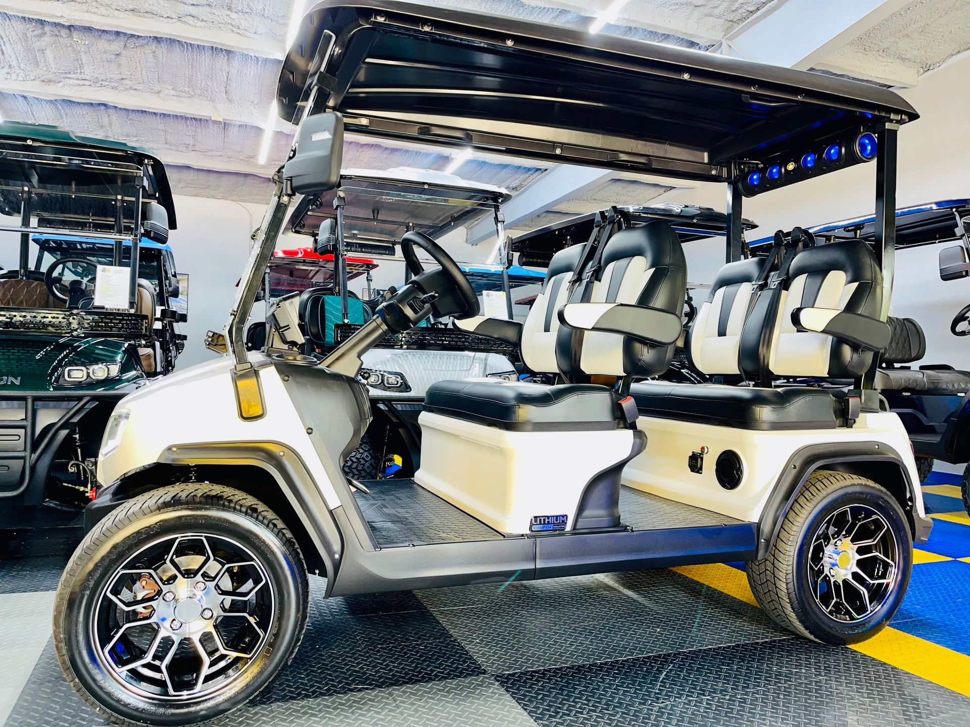 A white golf cart is parked in a showroom.