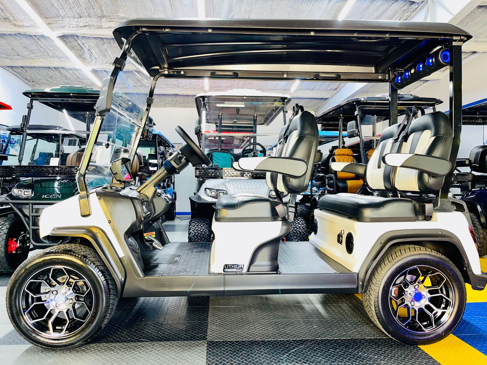 A white golf cart is parked in a garage.