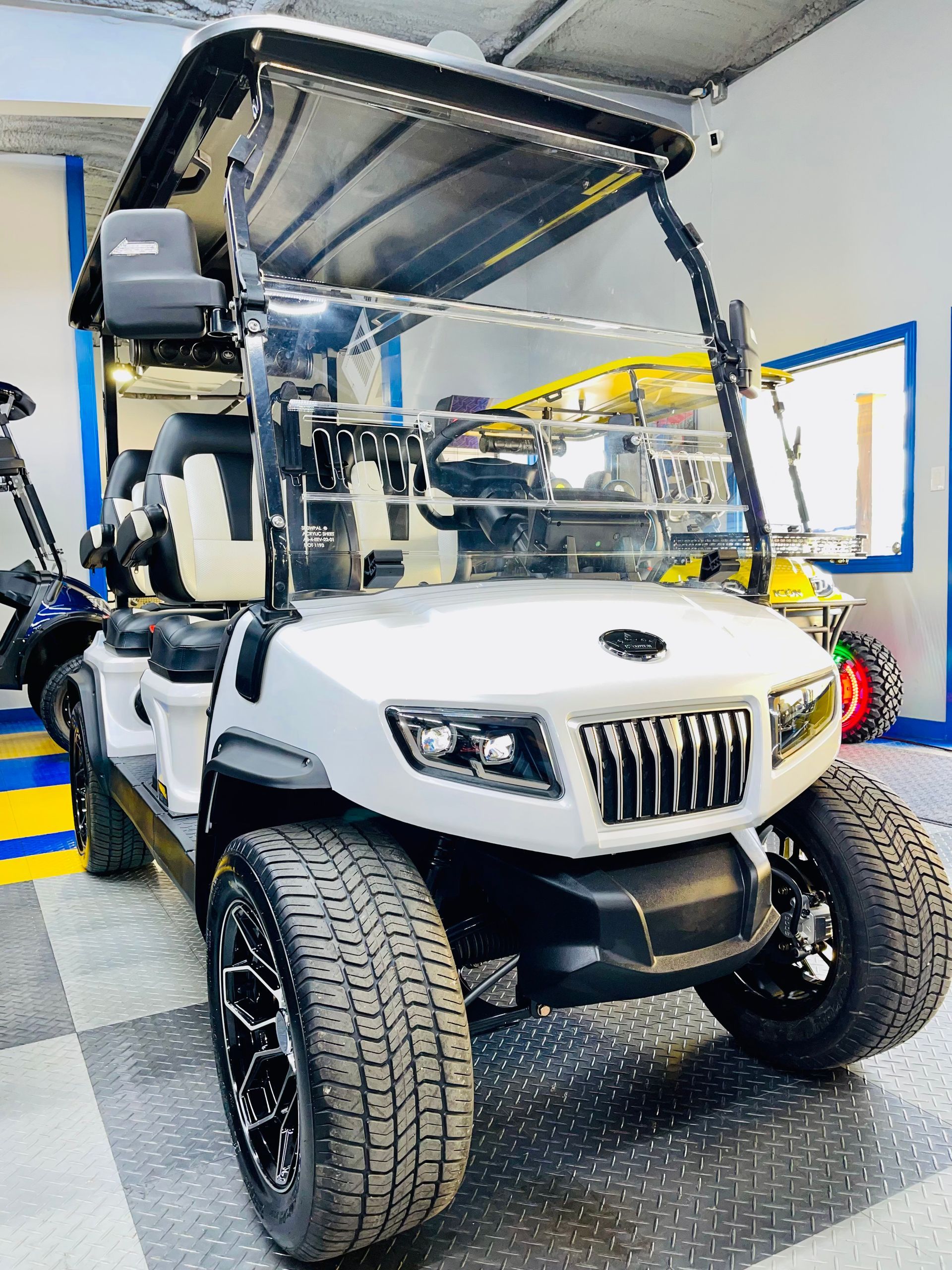 A white golf cart is parked in a garage.