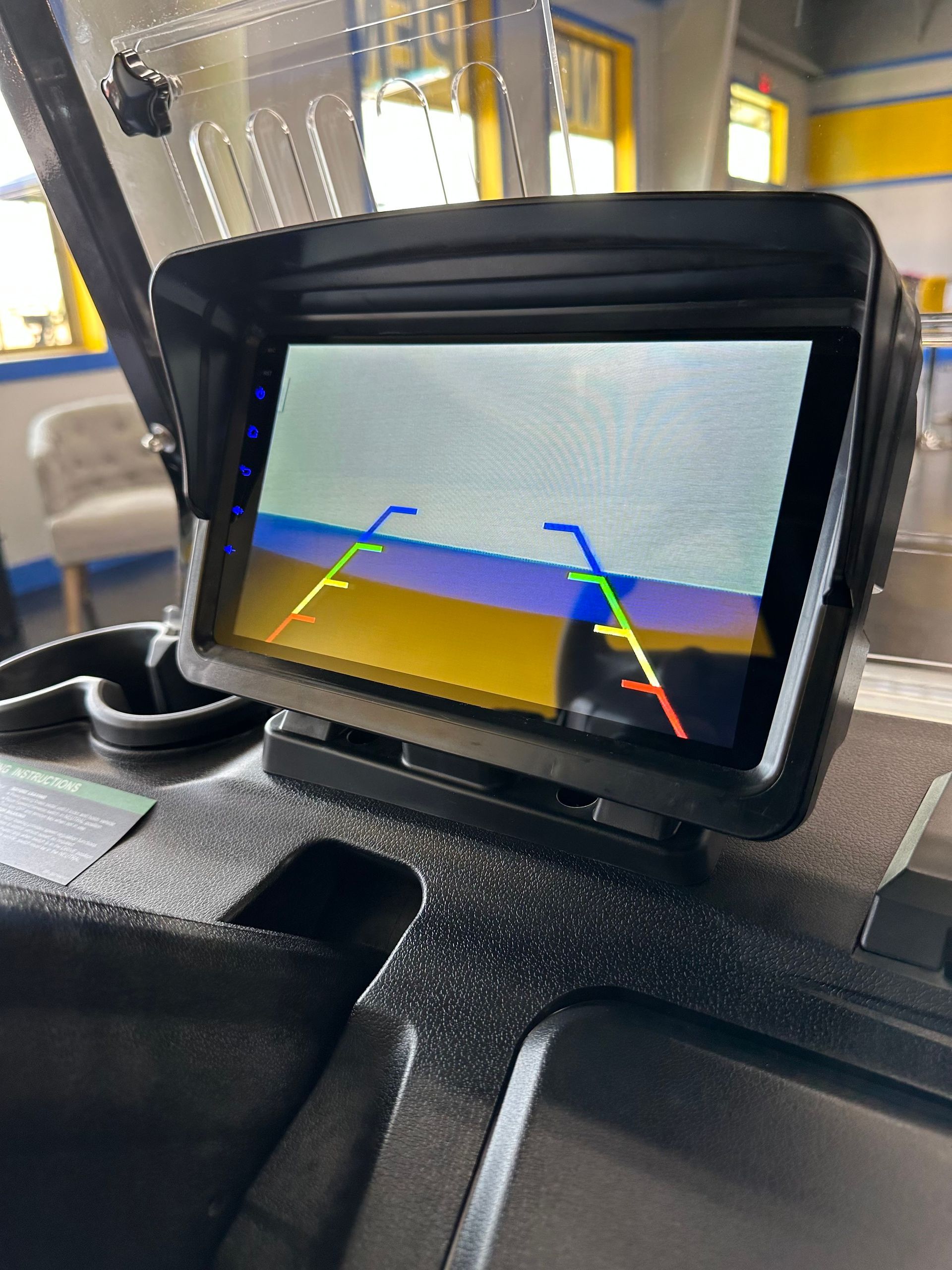 A rear view camera is mounted on the dashboard of a golf cart.