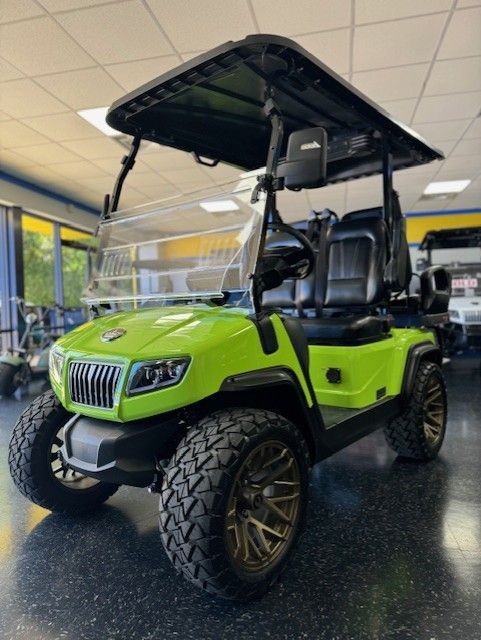 Lime green lifted golf cart with black roof and black seats, inside a showroom.