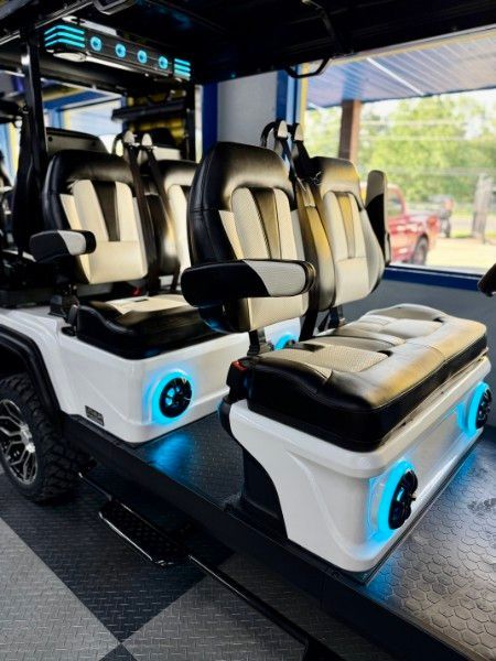 The inside of a golf cart with black and white seats