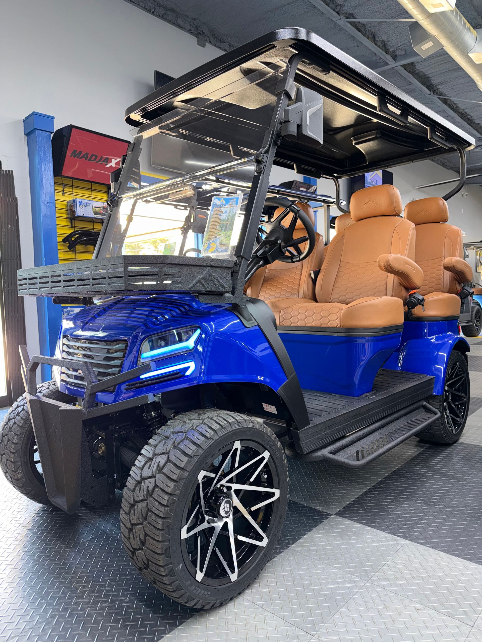 A blue golf cart is parked in front of a lacey 's golf store.