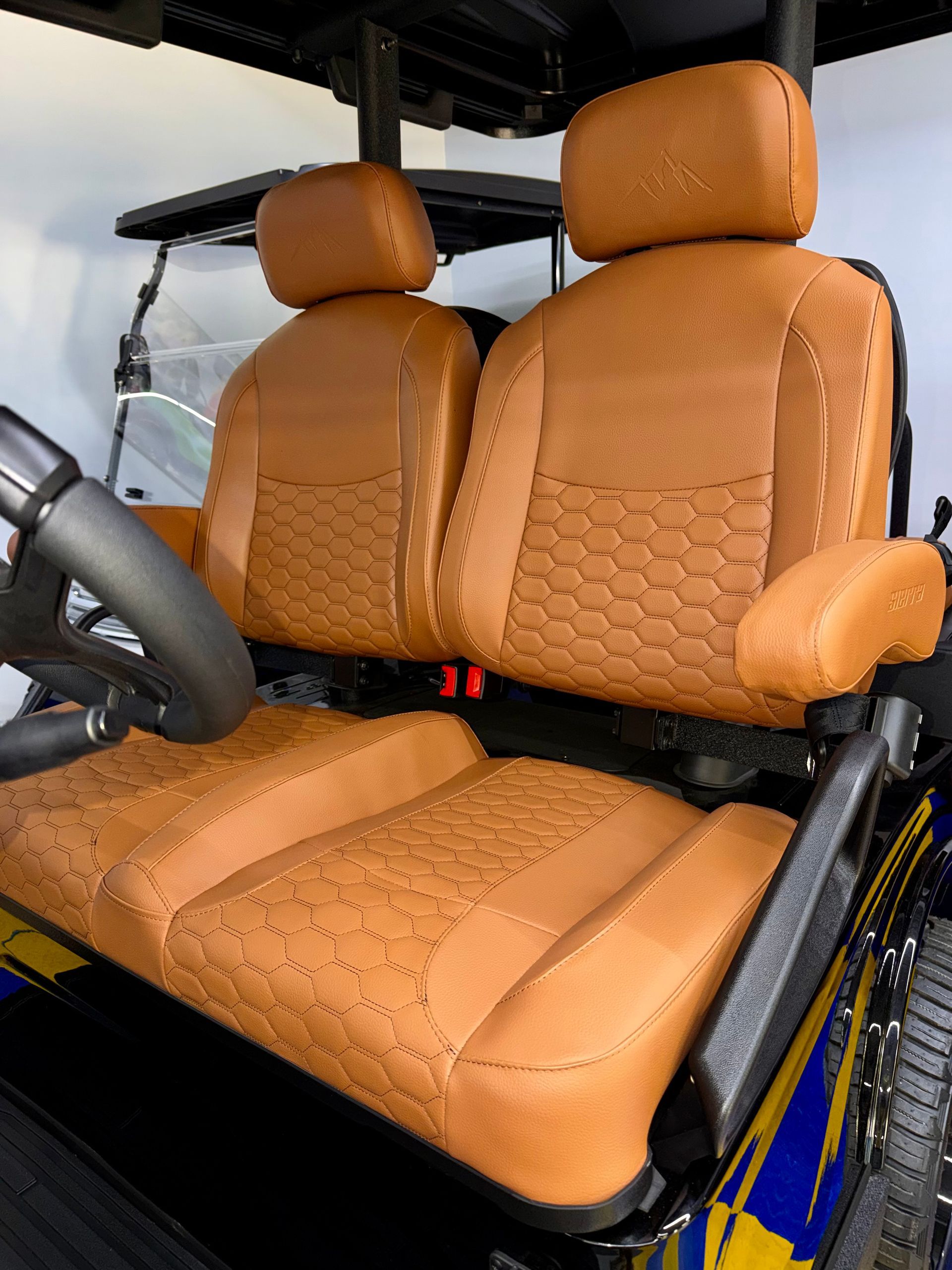 Orange car seats with headrests and steering wheel inside a vehicle interior