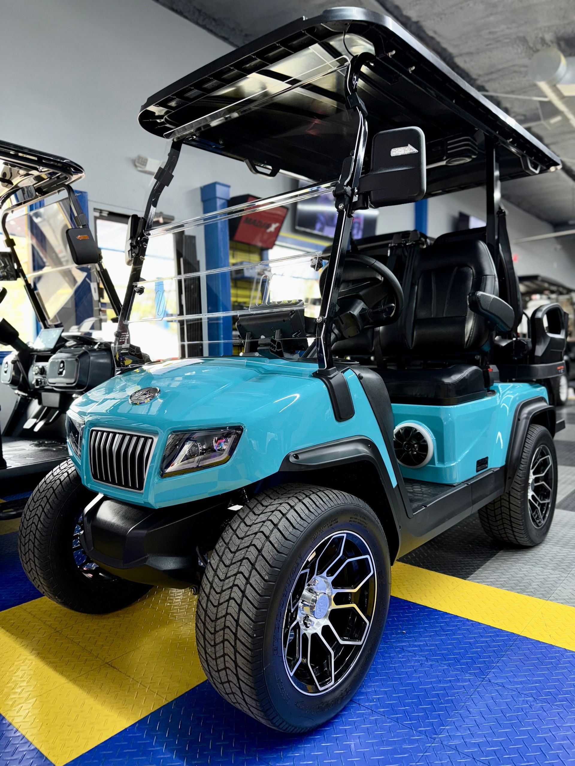 A blue golf cart is parked in a garage.