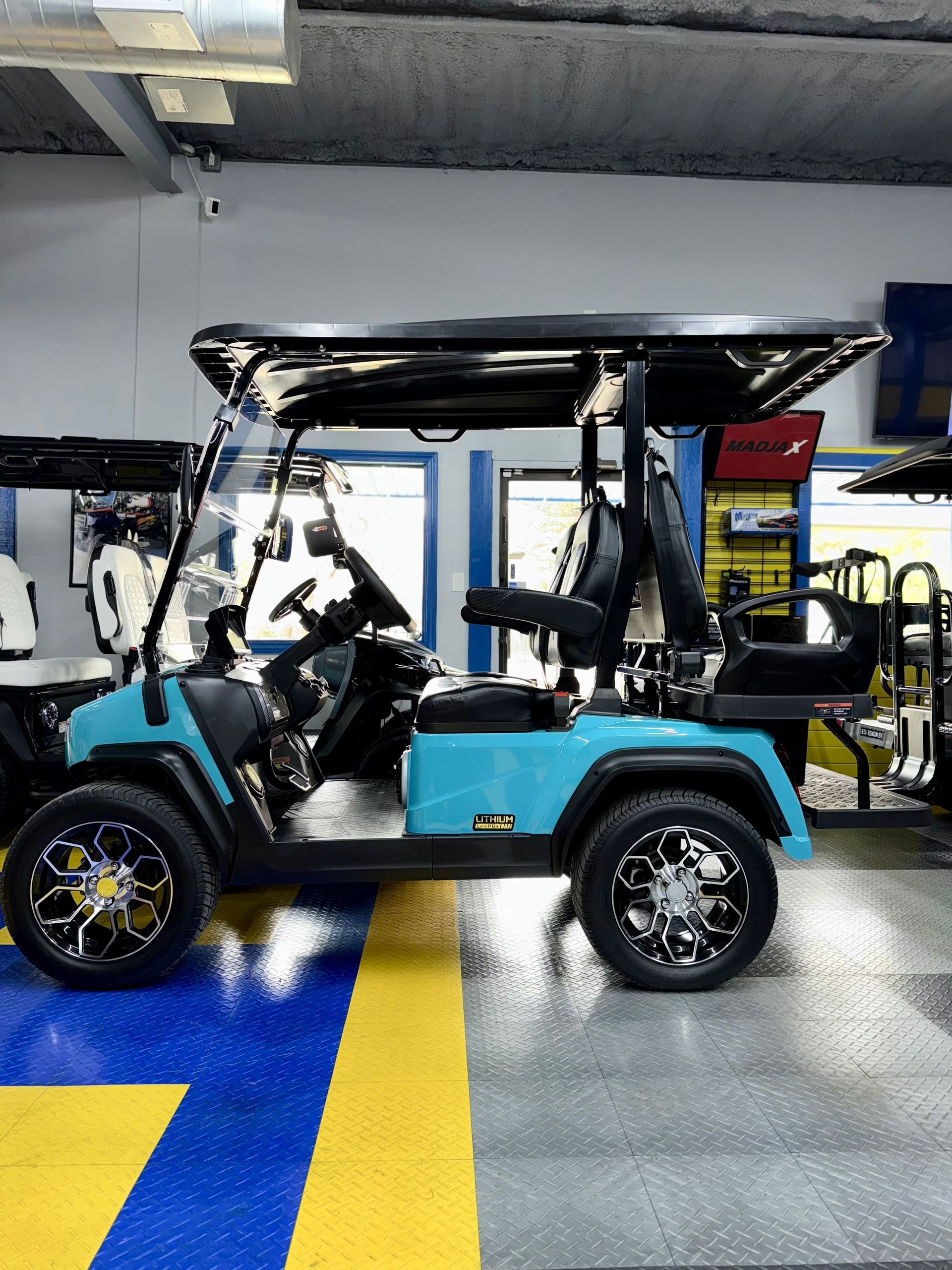 A blue golf cart is parked in a garage