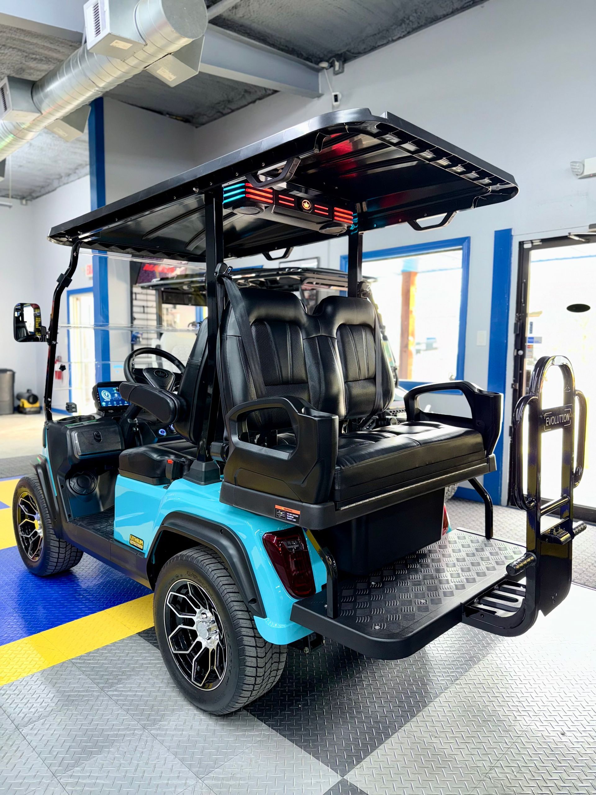A blue golf cart is parked in a garage.