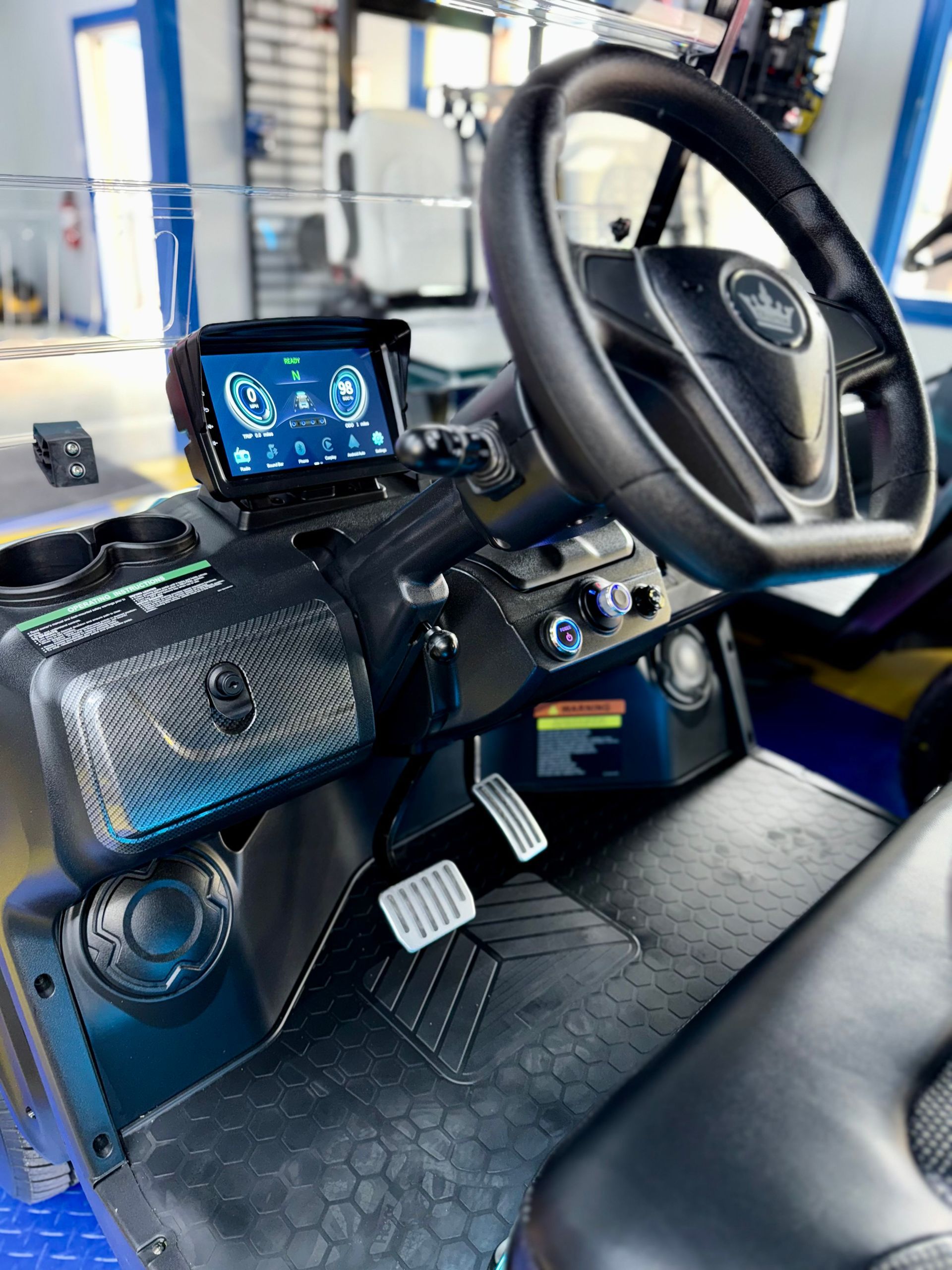 The interior of a golf cart with a steering wheel and dashboard