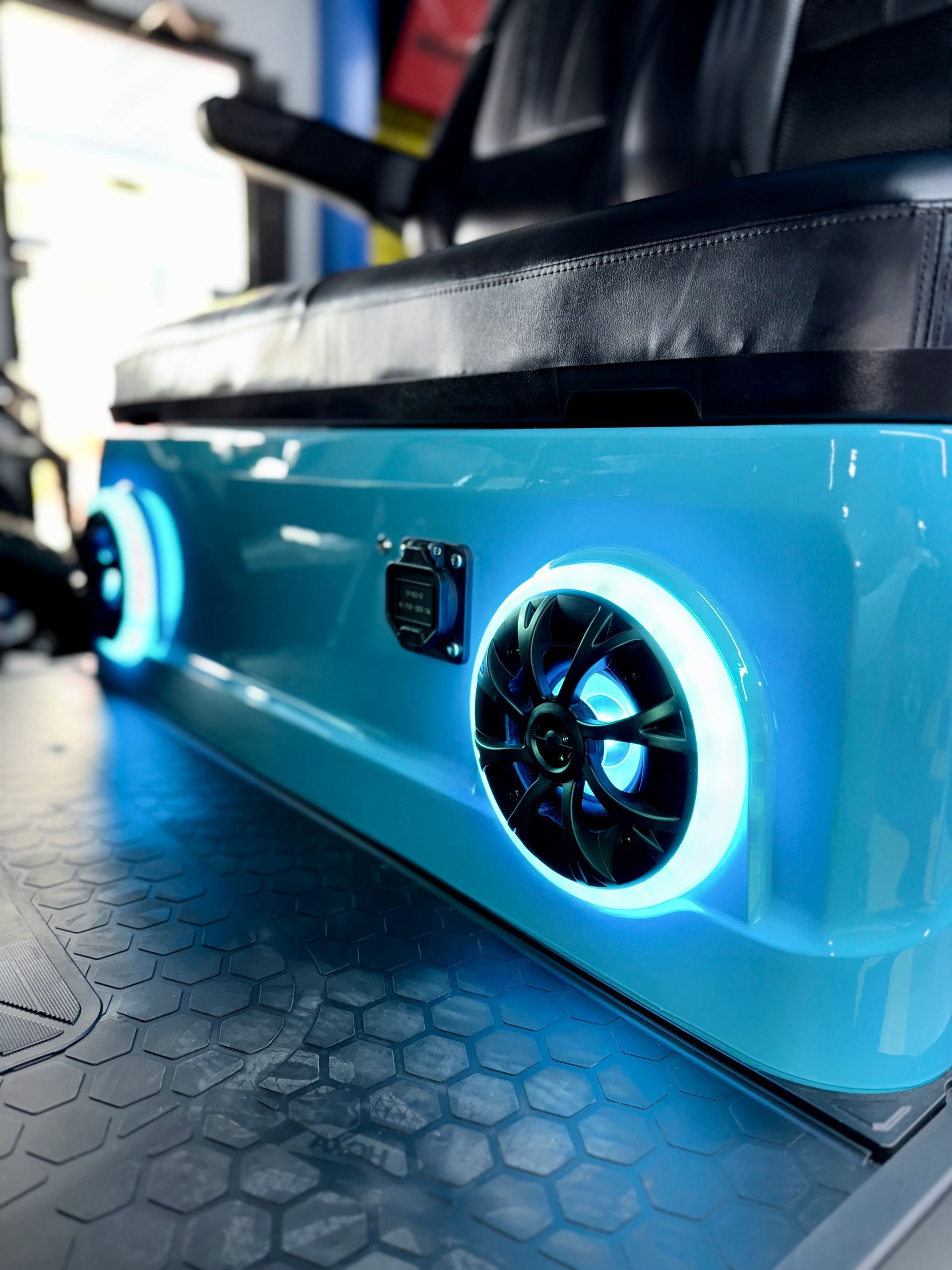 A blue golf cart with speakers and lights on it