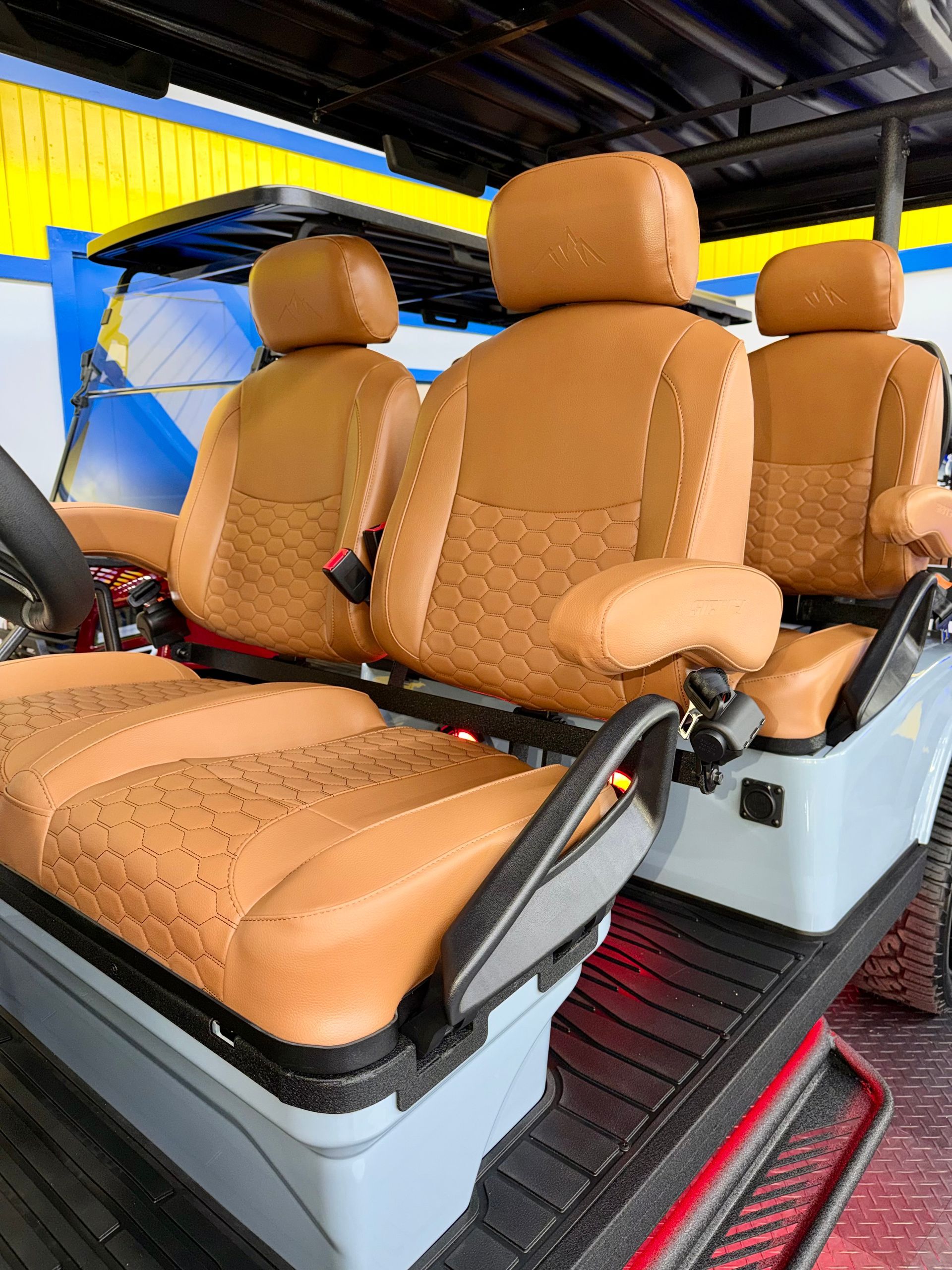 Tan leather car seats with matching headrests in a vehicle interior, viewed from the front passenger side.