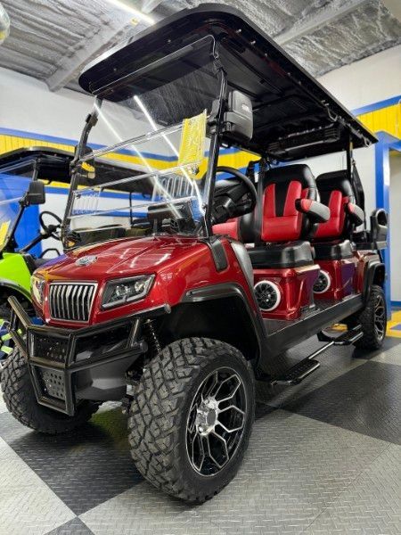 A red golf cart is parked in a garage
