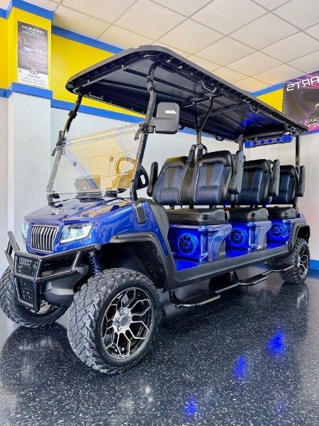 A blue golf cart is parked in a garage.