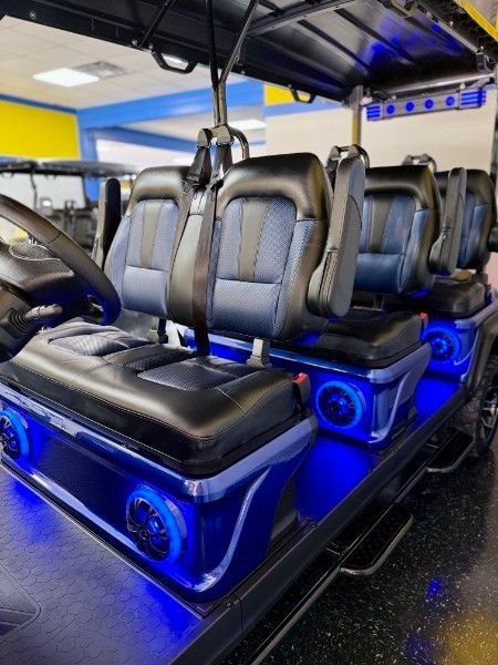 The inside of a golf cart with blue lights and speakers.