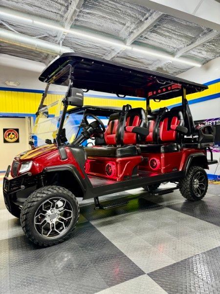 A red golf cart is parked in a garage.