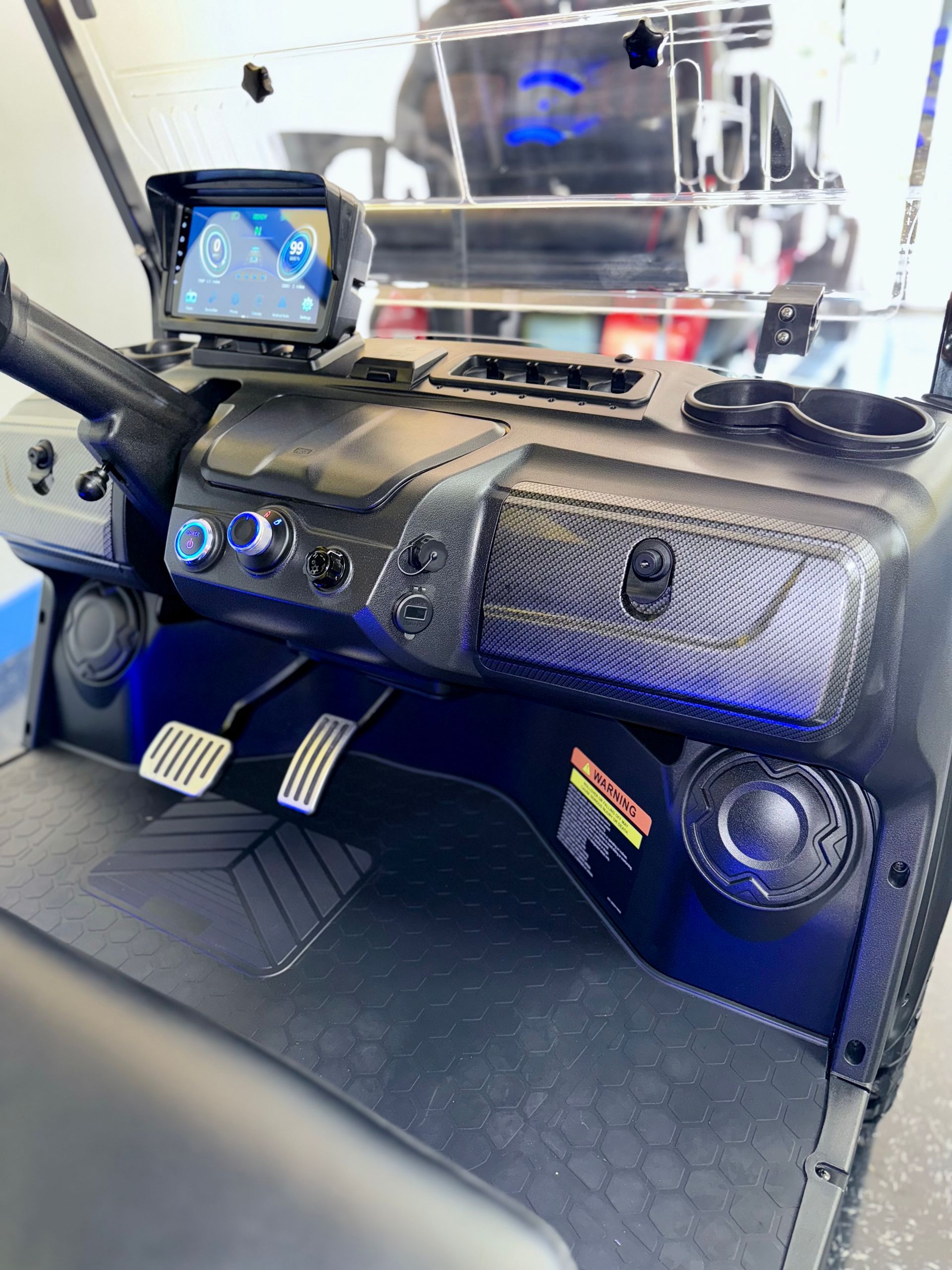 The dashboard of a golf cart with speakers and a gps.