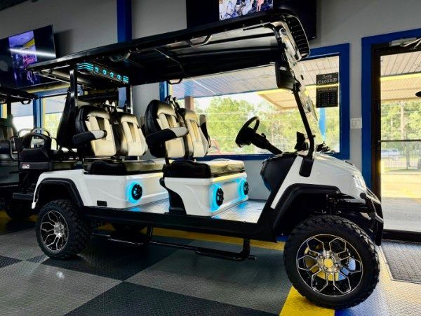 A white golf cart is parked in a garage.