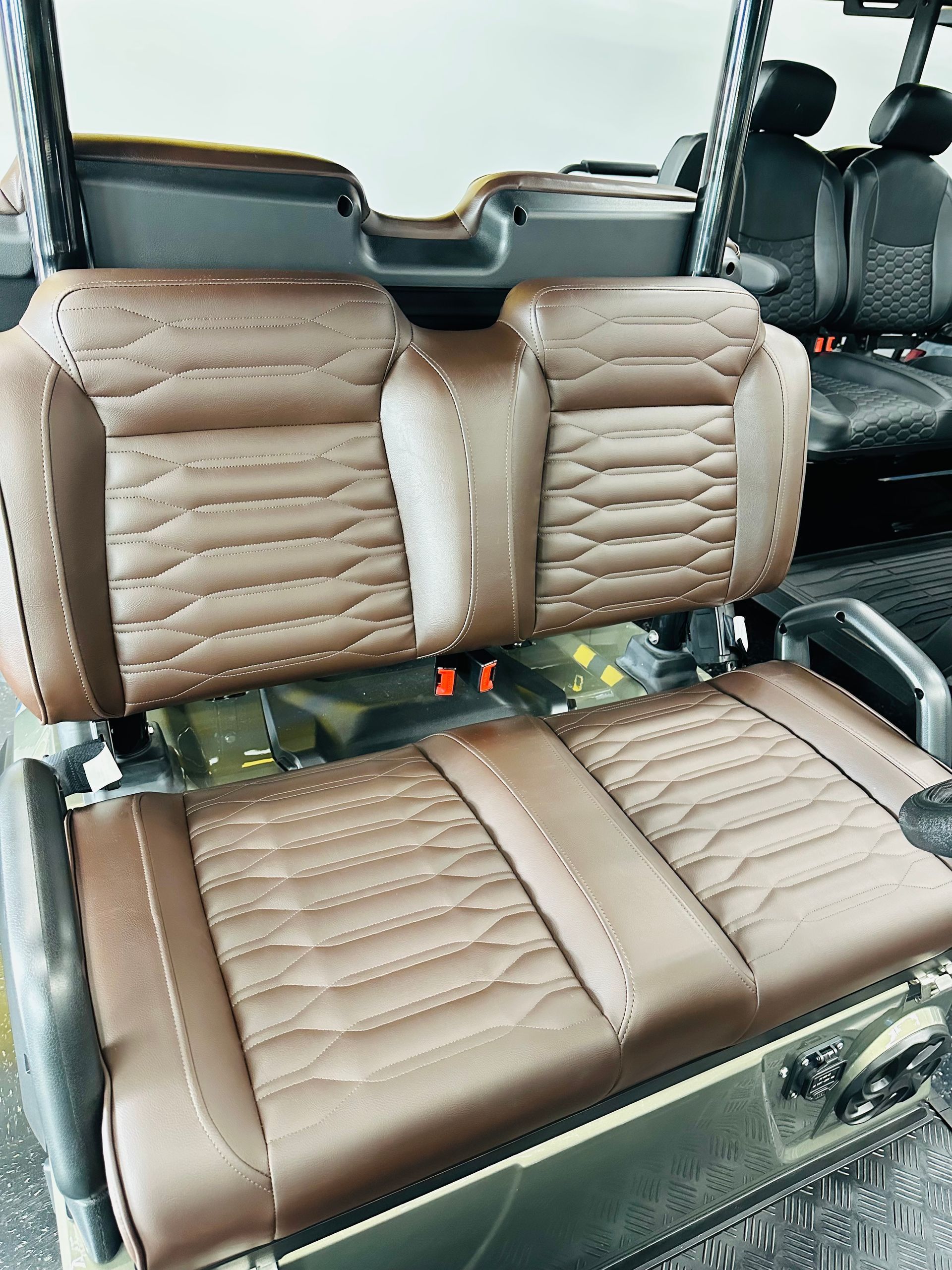 Tan leather car seat covers on front and rear seats inside a vehicle interior.