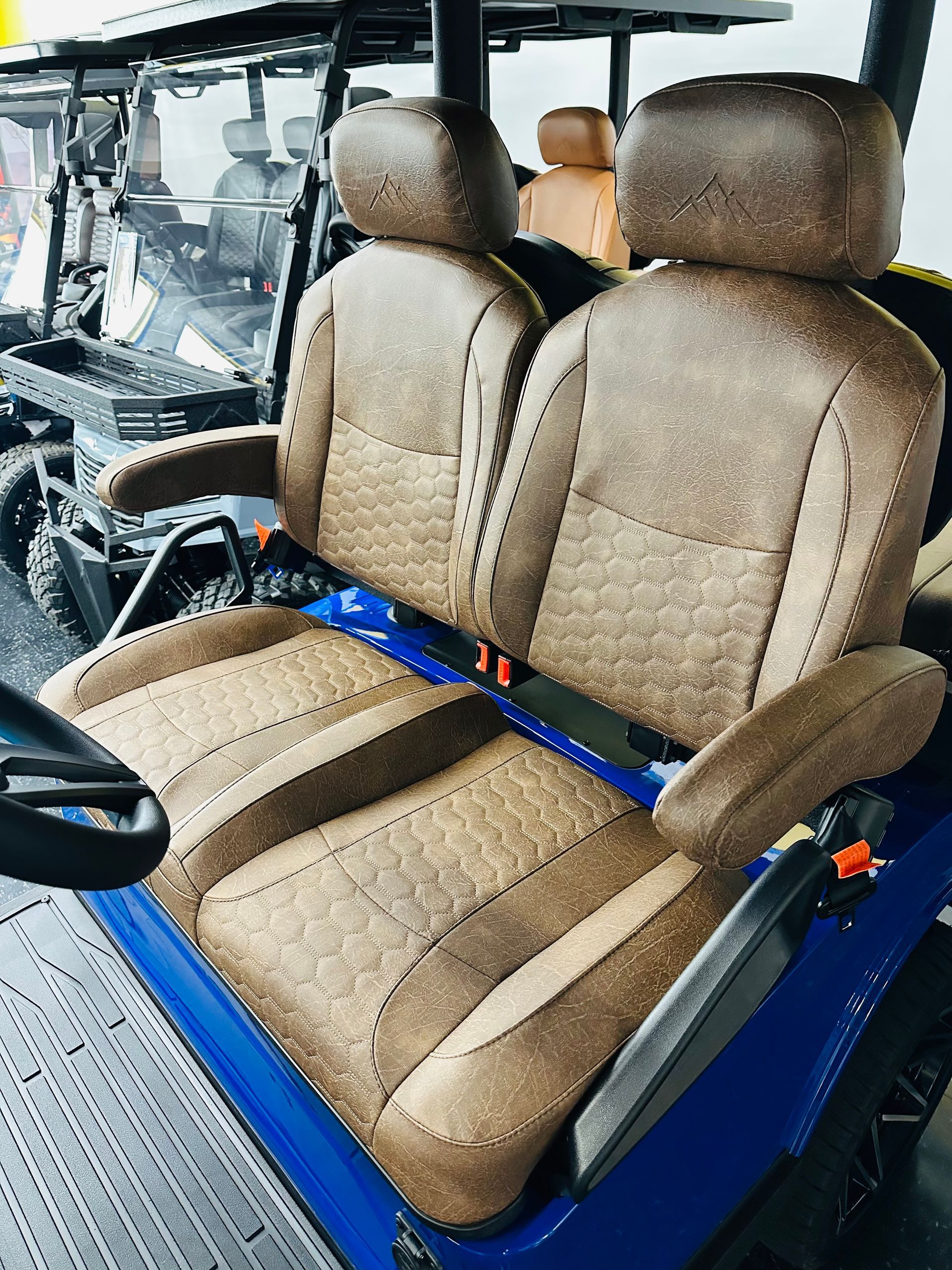 Blue vehicle interior with tan leather front bucket seats and dashboard visible