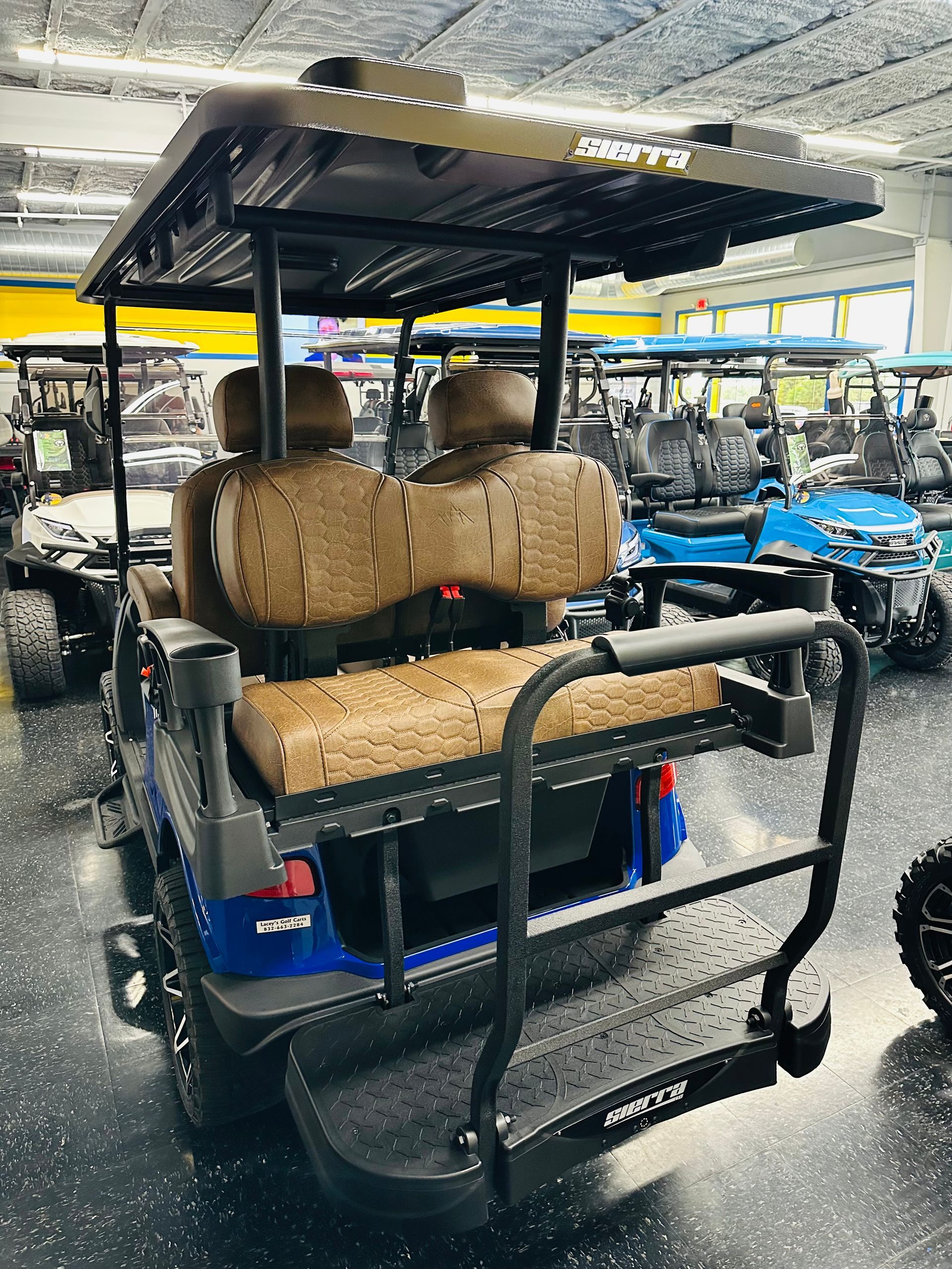 Black utility cart with woven seats and canopy in a rainy parking lot