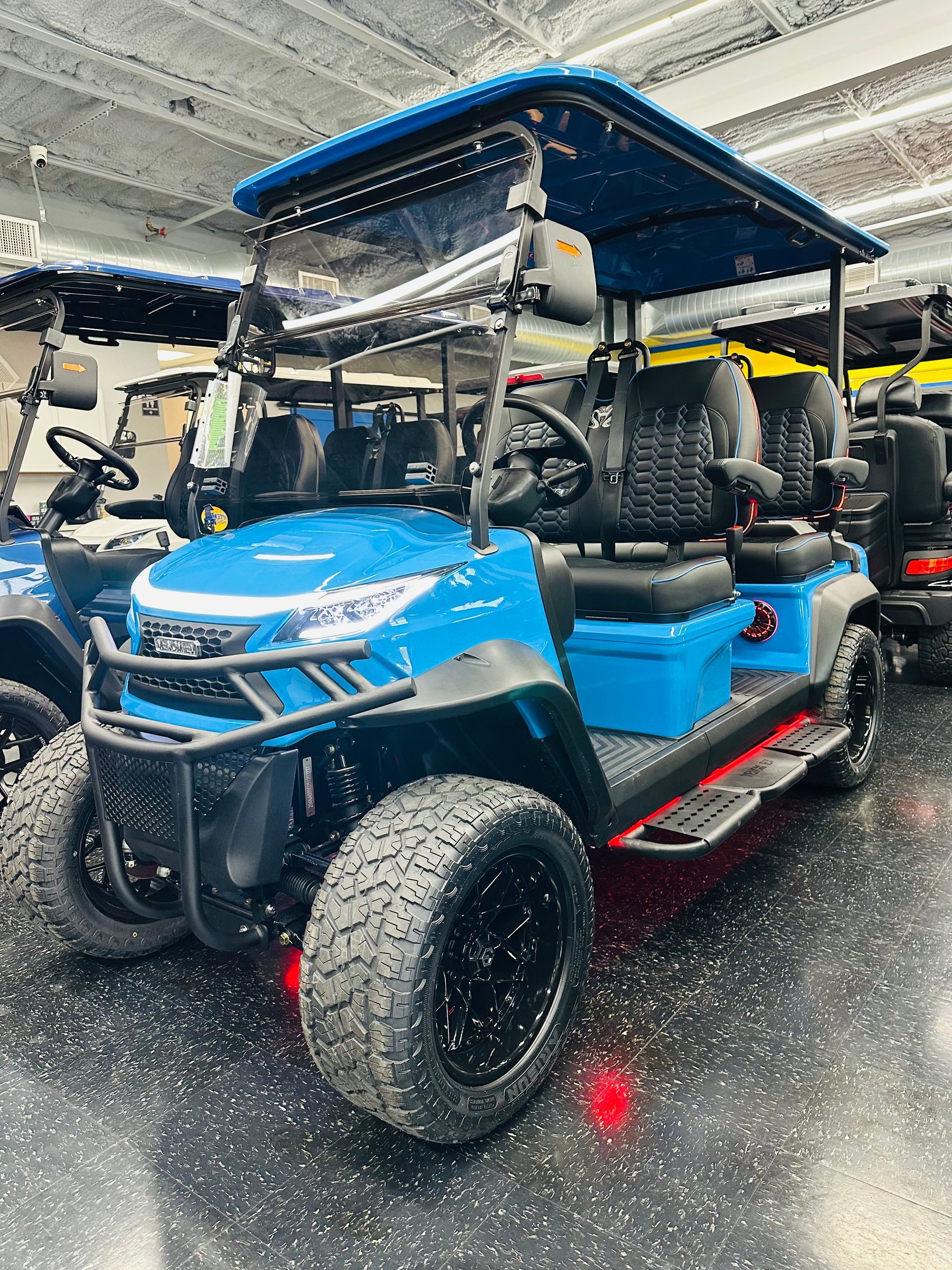 A white golf cart is parked in a showroom.