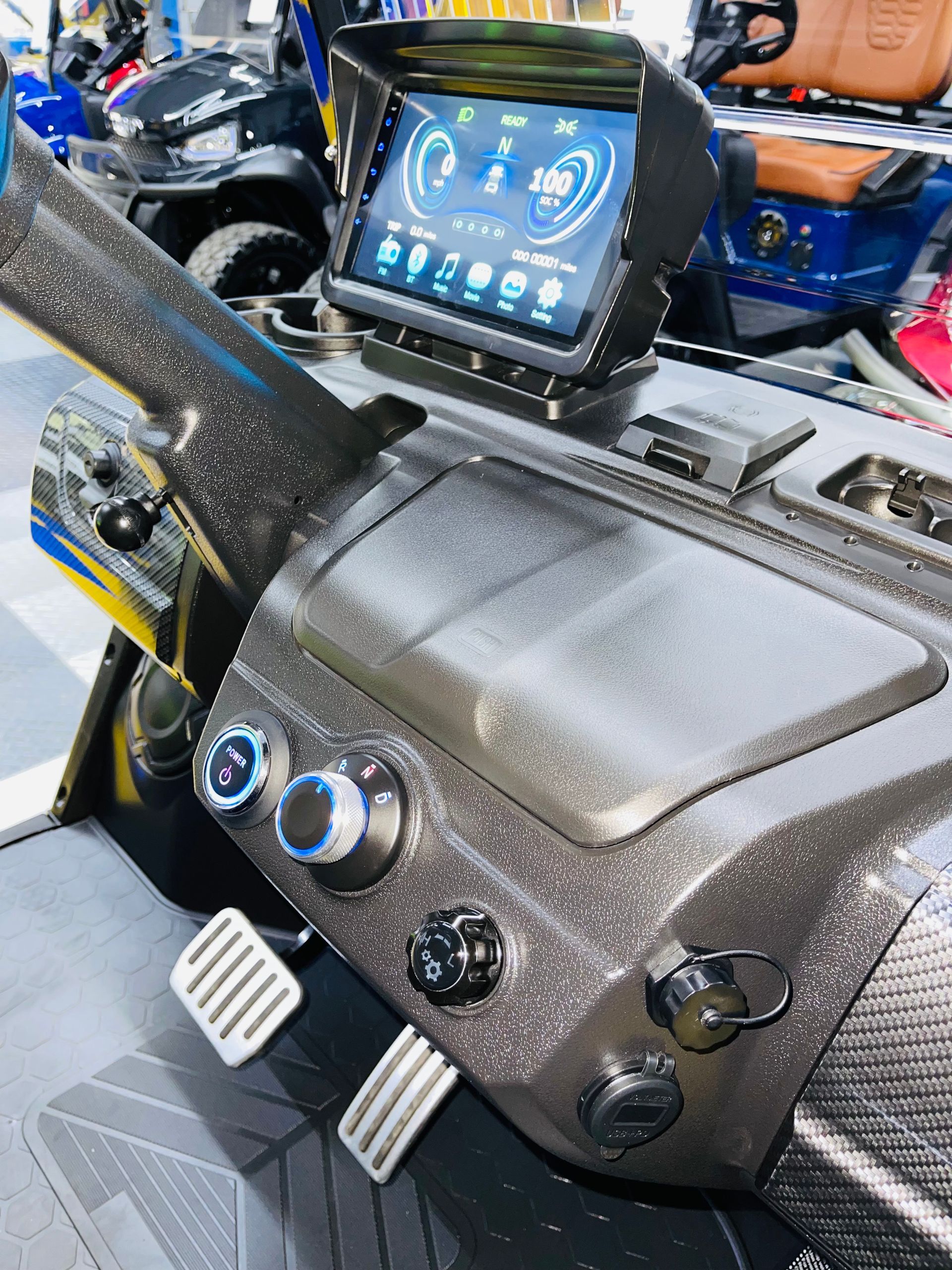 The dashboard of a golf cart with a tablet on top of it.
