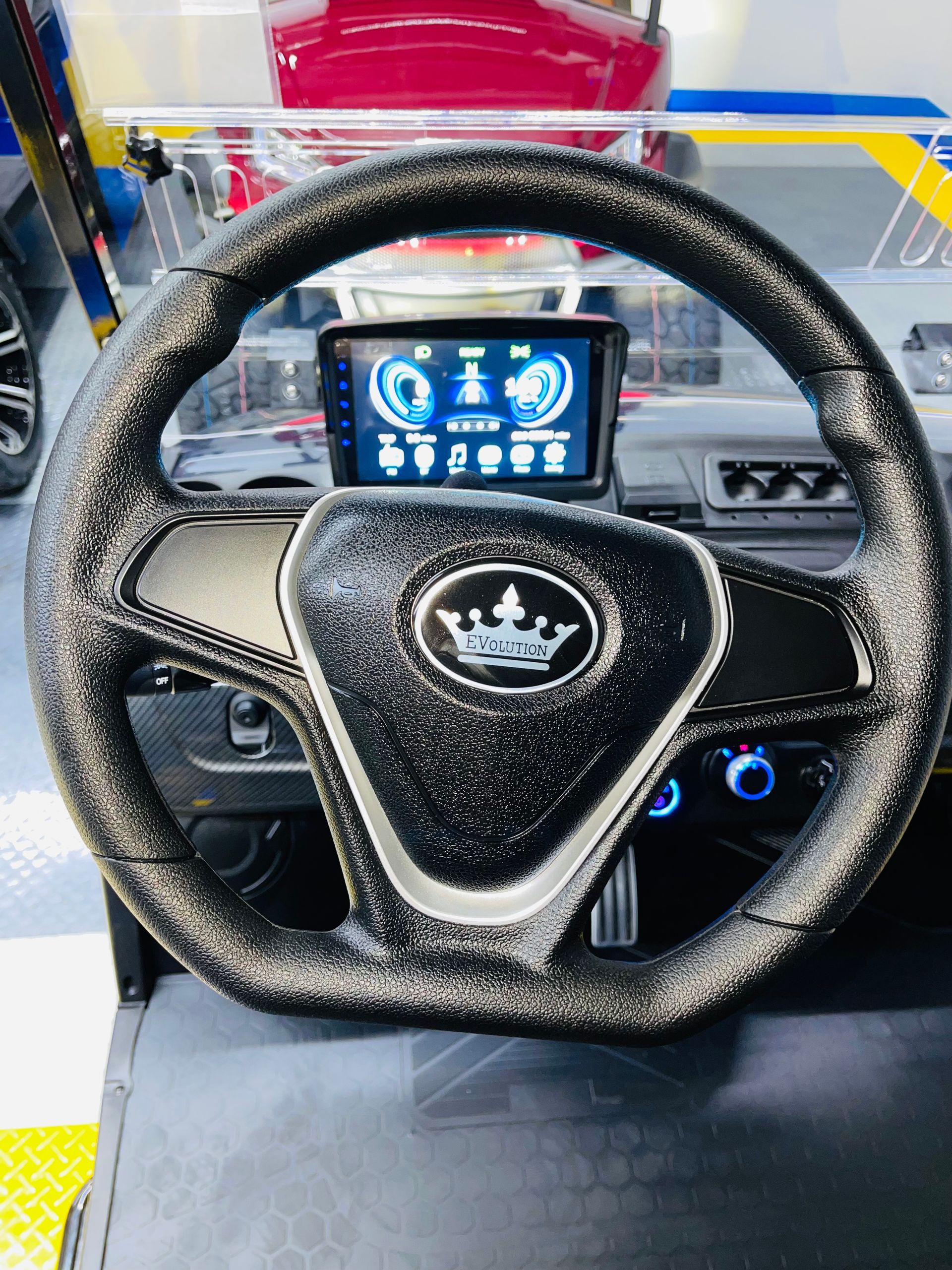 The steering wheel of a golf cart with a crown on it.