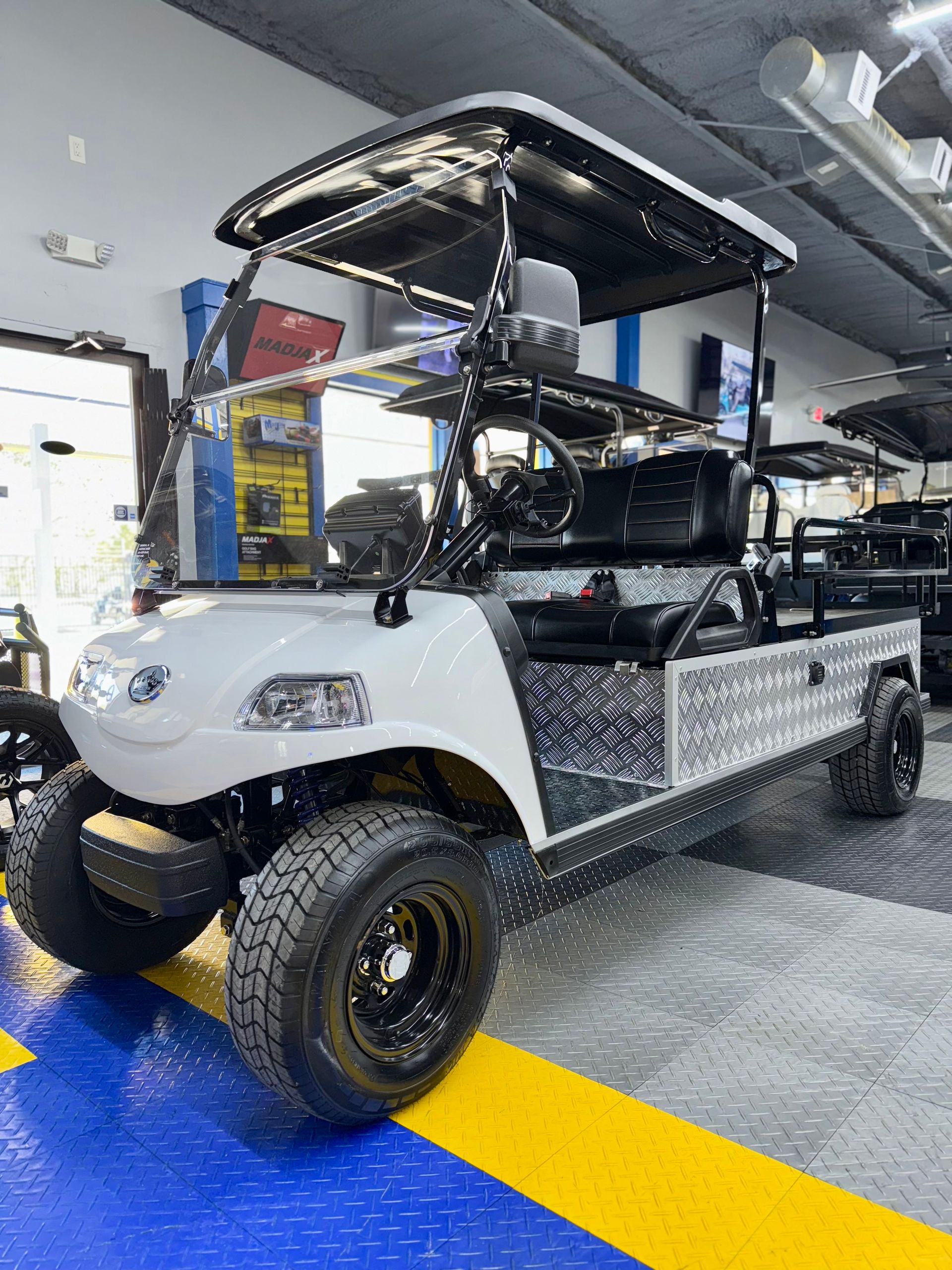A white golf cart is parked in a garage.