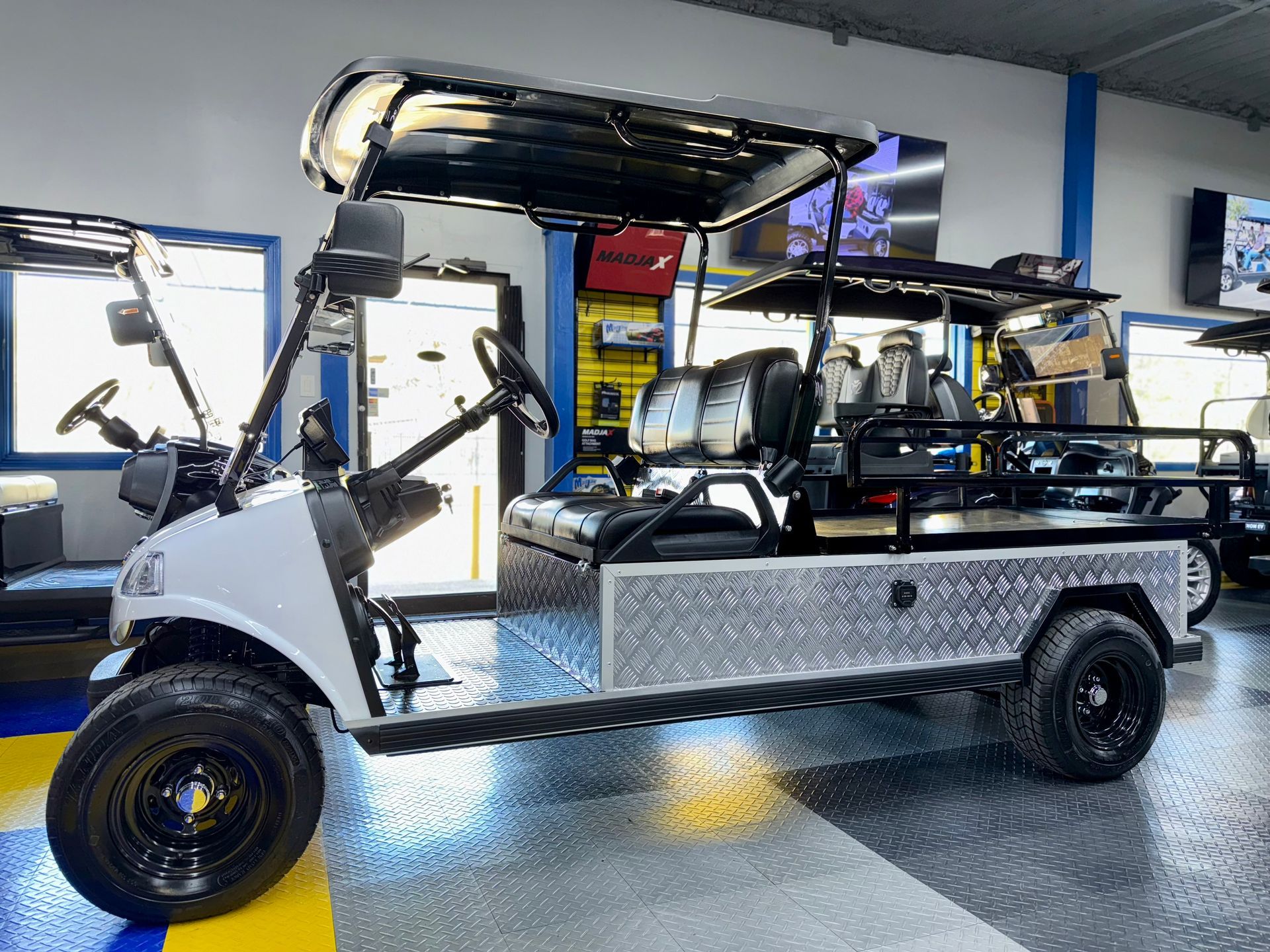 A white golf cart is parked in a garage.