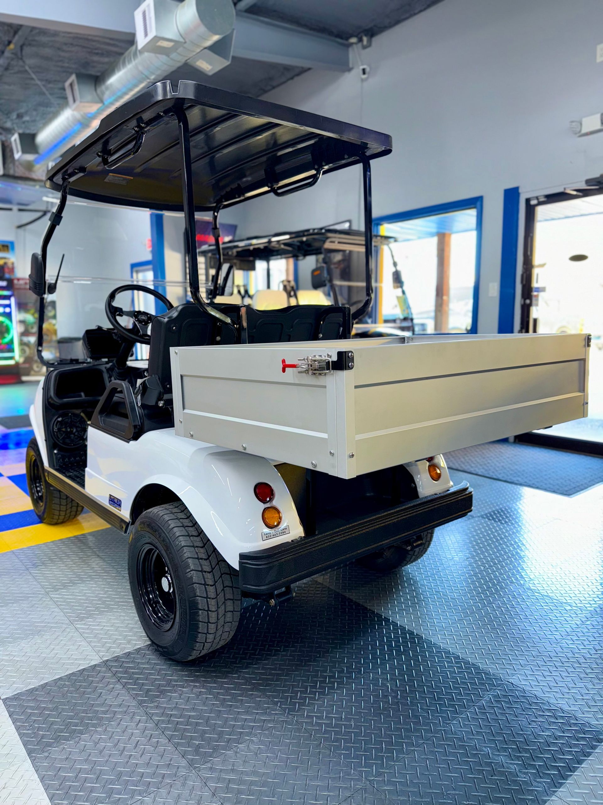 A white golf cart is parked in a garage.