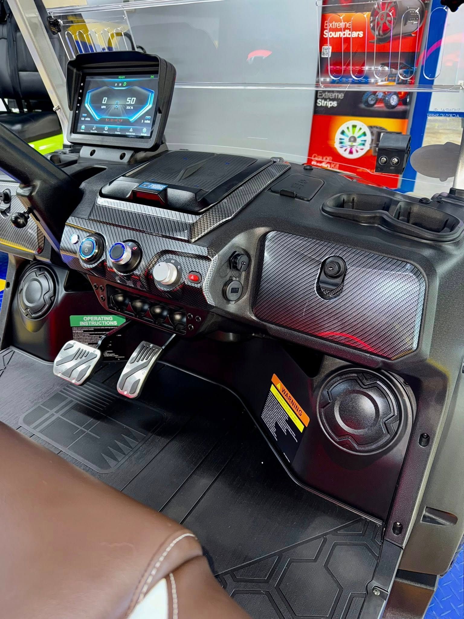 A close up of the dashboard of a boat with a steering wheel and controls.