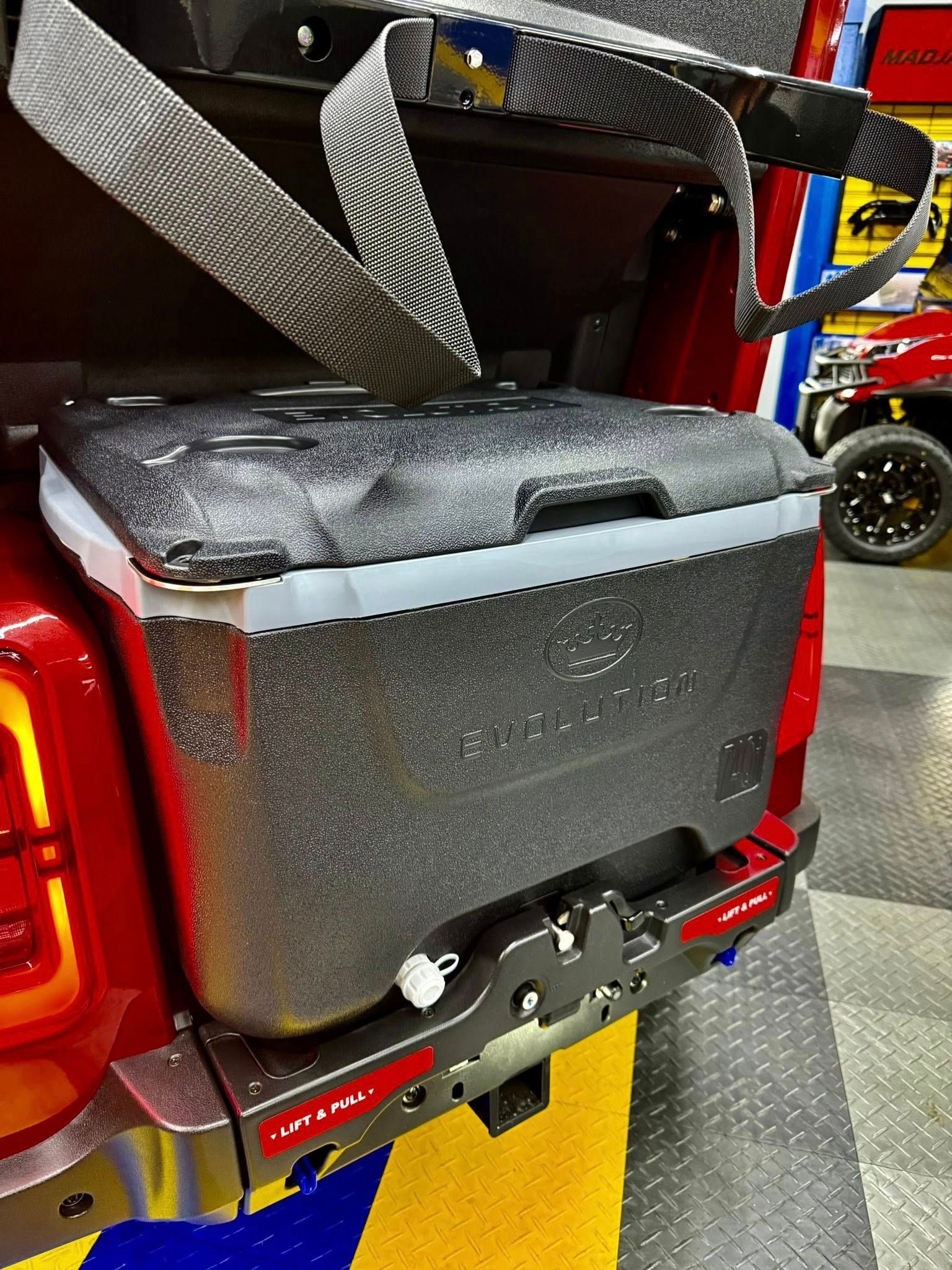 A red truck with a cooler attached to the back of it.