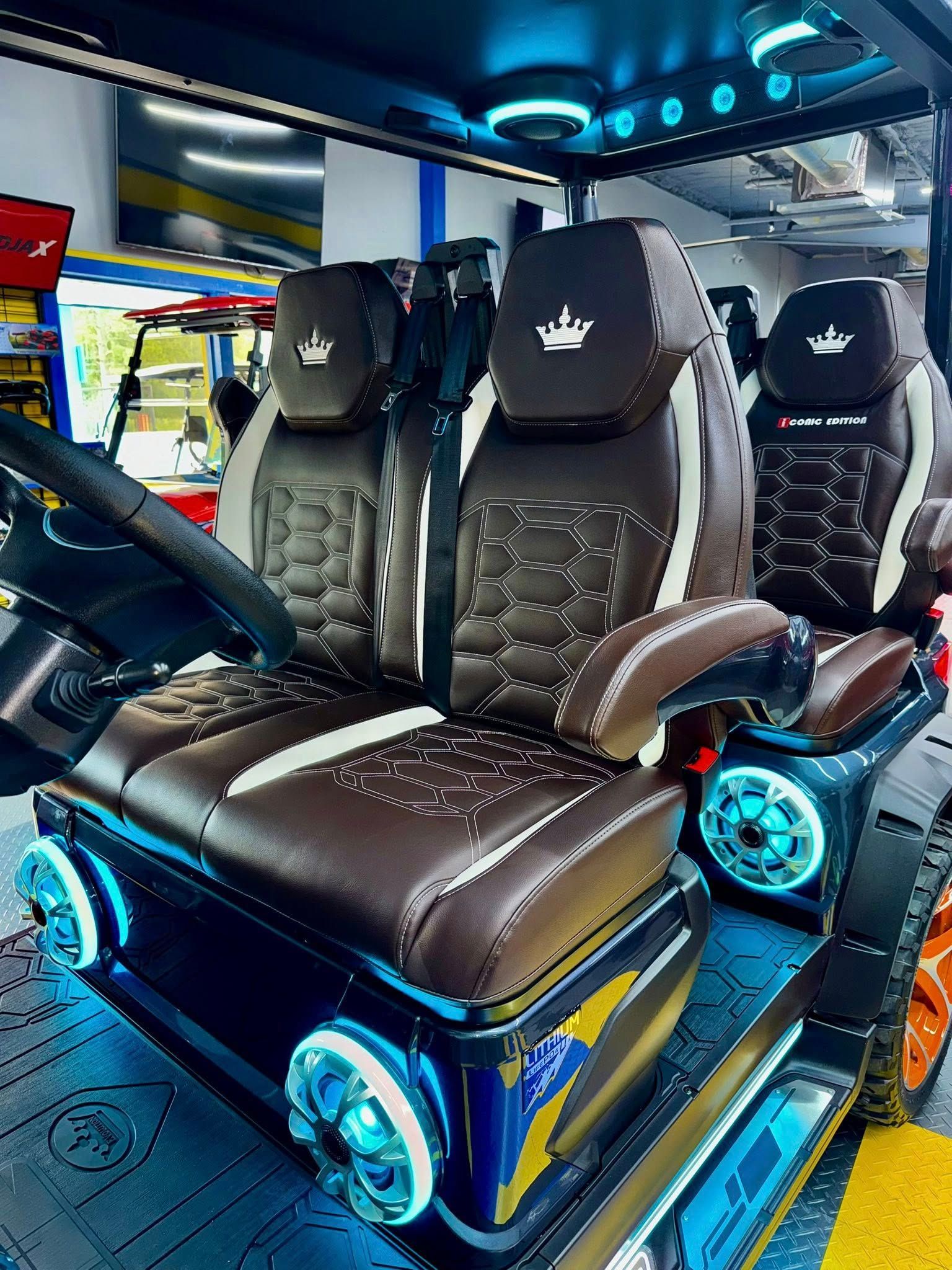 A golf cart with a crown on the seats is parked in a garage.