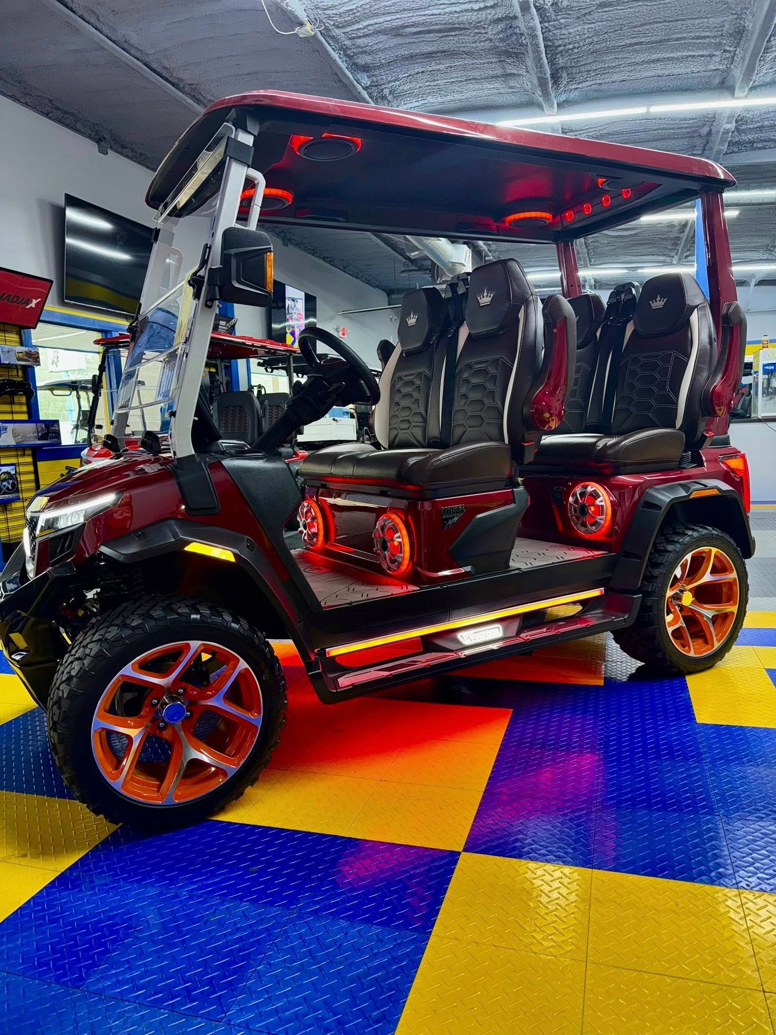 A red golf cart is parked on a checkered floor in a garage.