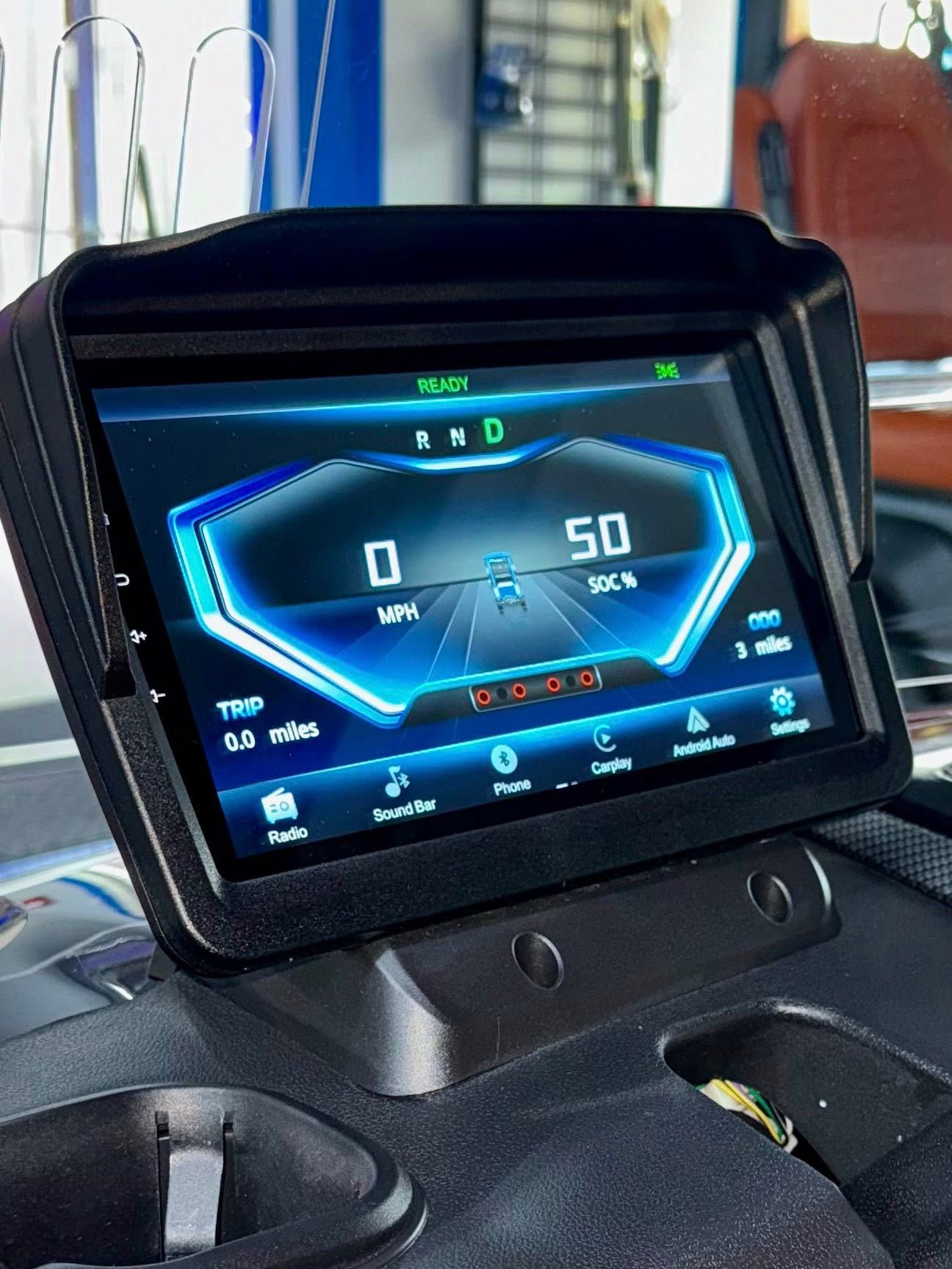 A tablet is sitting on top of a car dashboard.