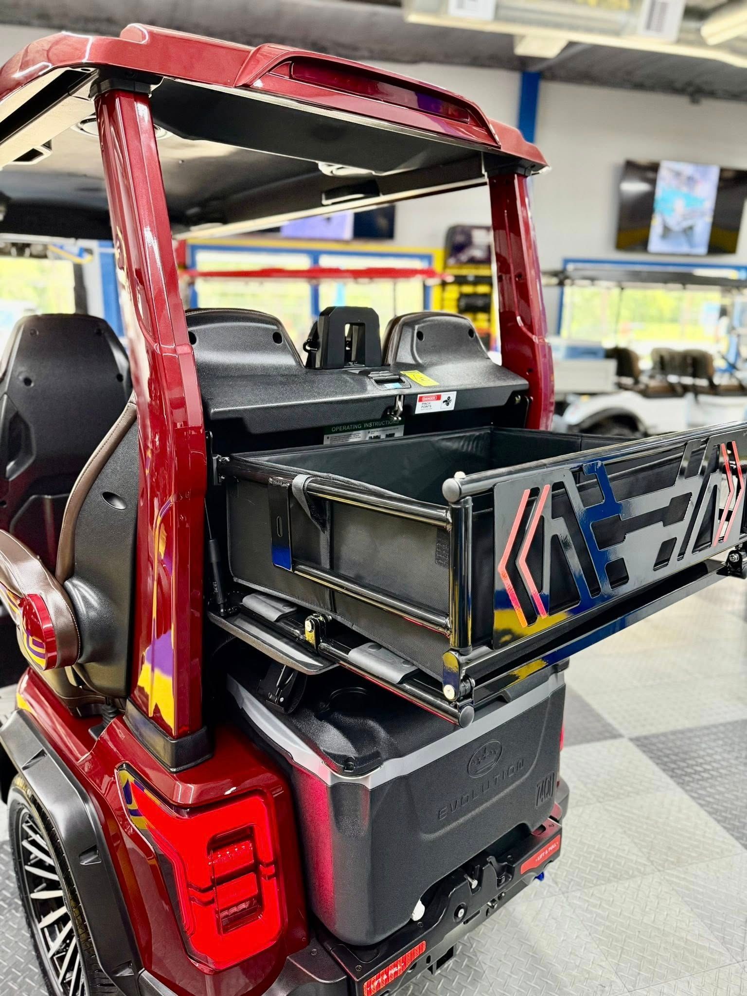 A red golf cart with a drawer in the back of it.