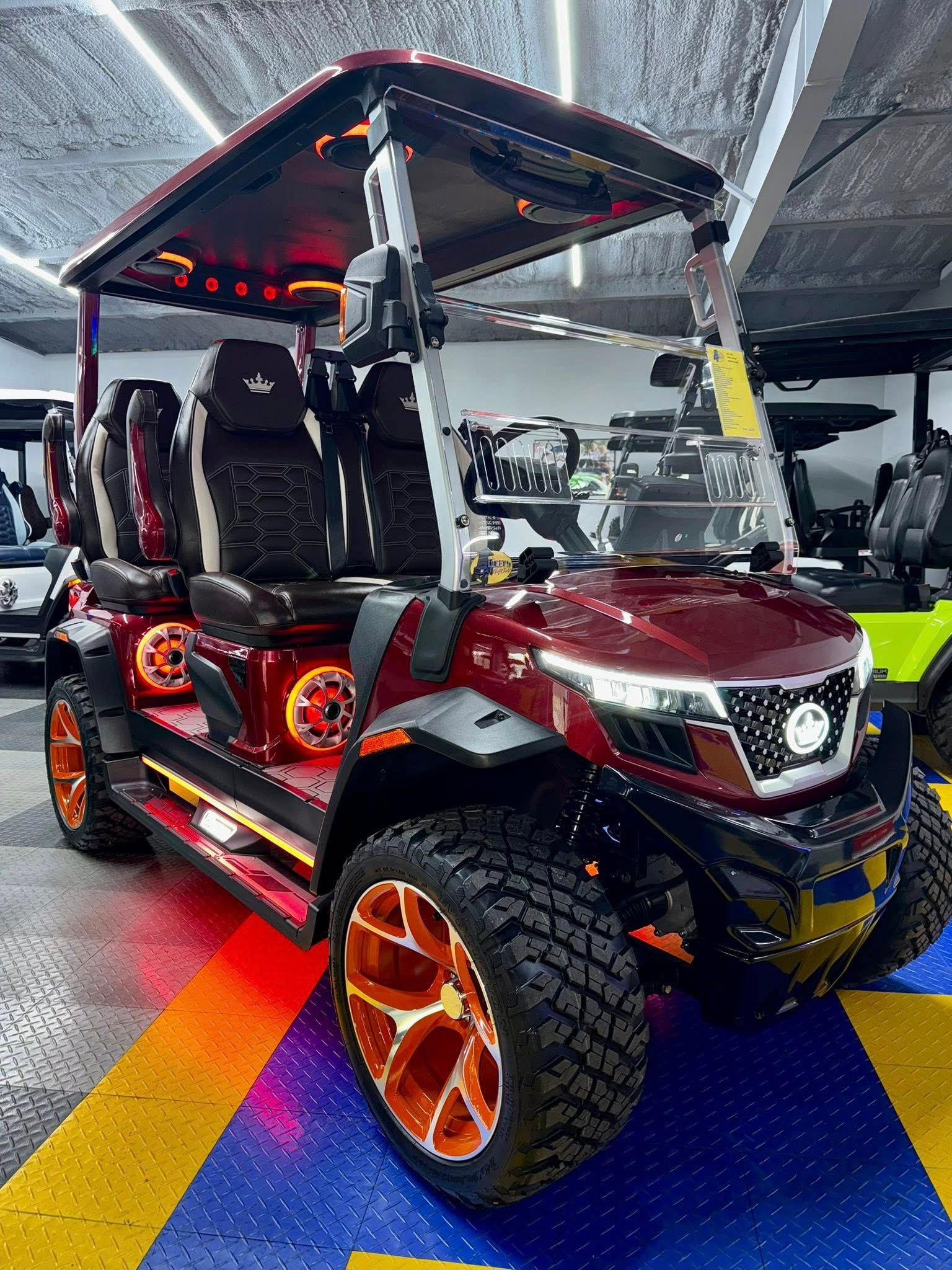 A red golf cart is parked in a showroom.