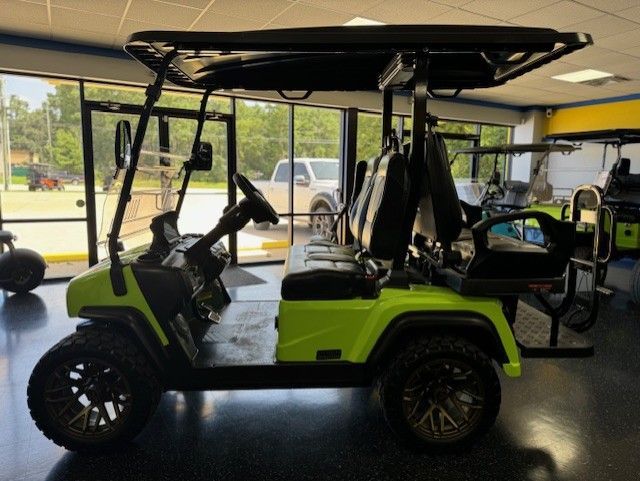 Bright green golf cart with black accents and large wheels, parked inside a showroom.