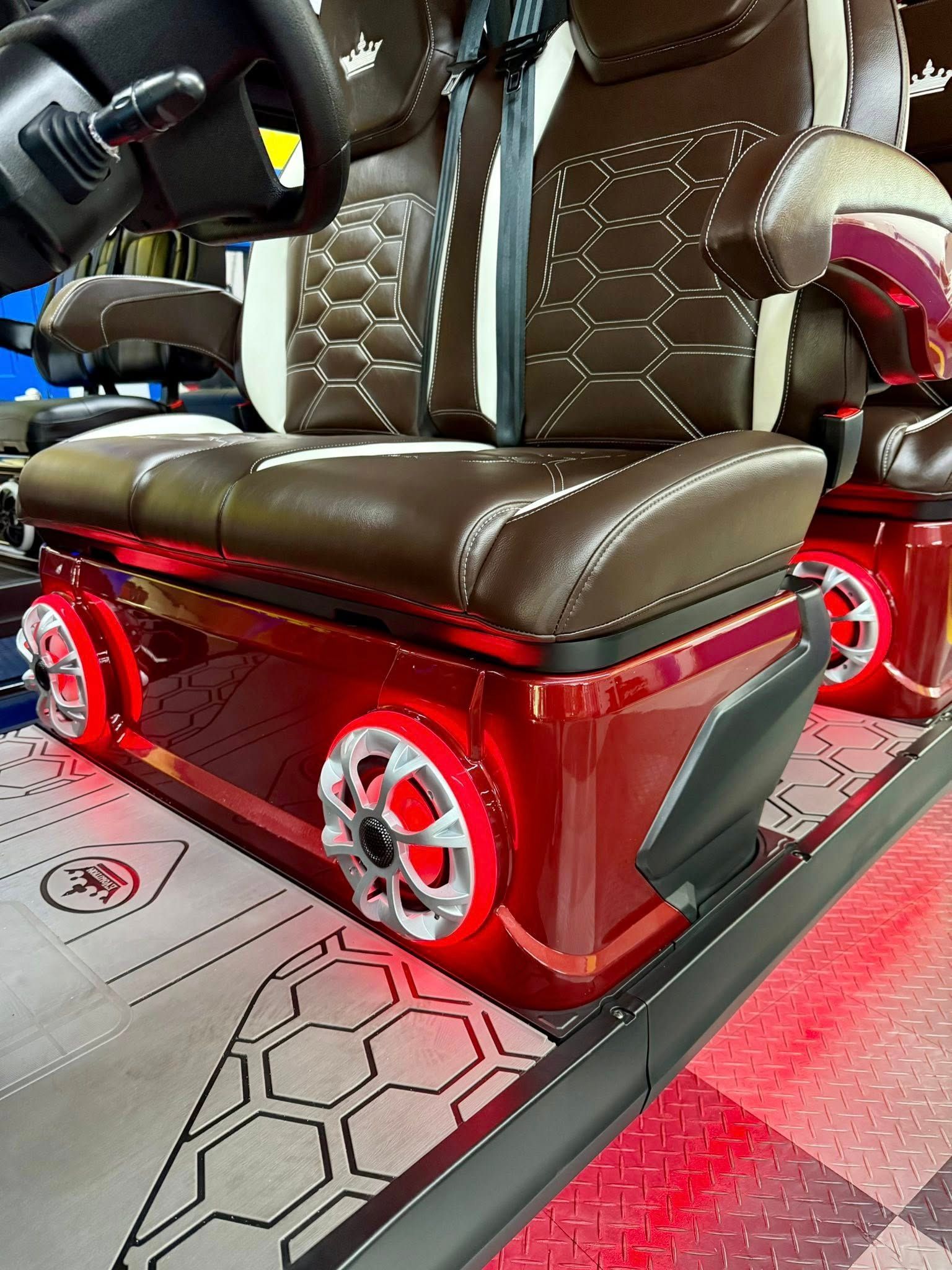 Brown and red gaming chair with LED lights, positioned on a platform with a honeycomb pattern.