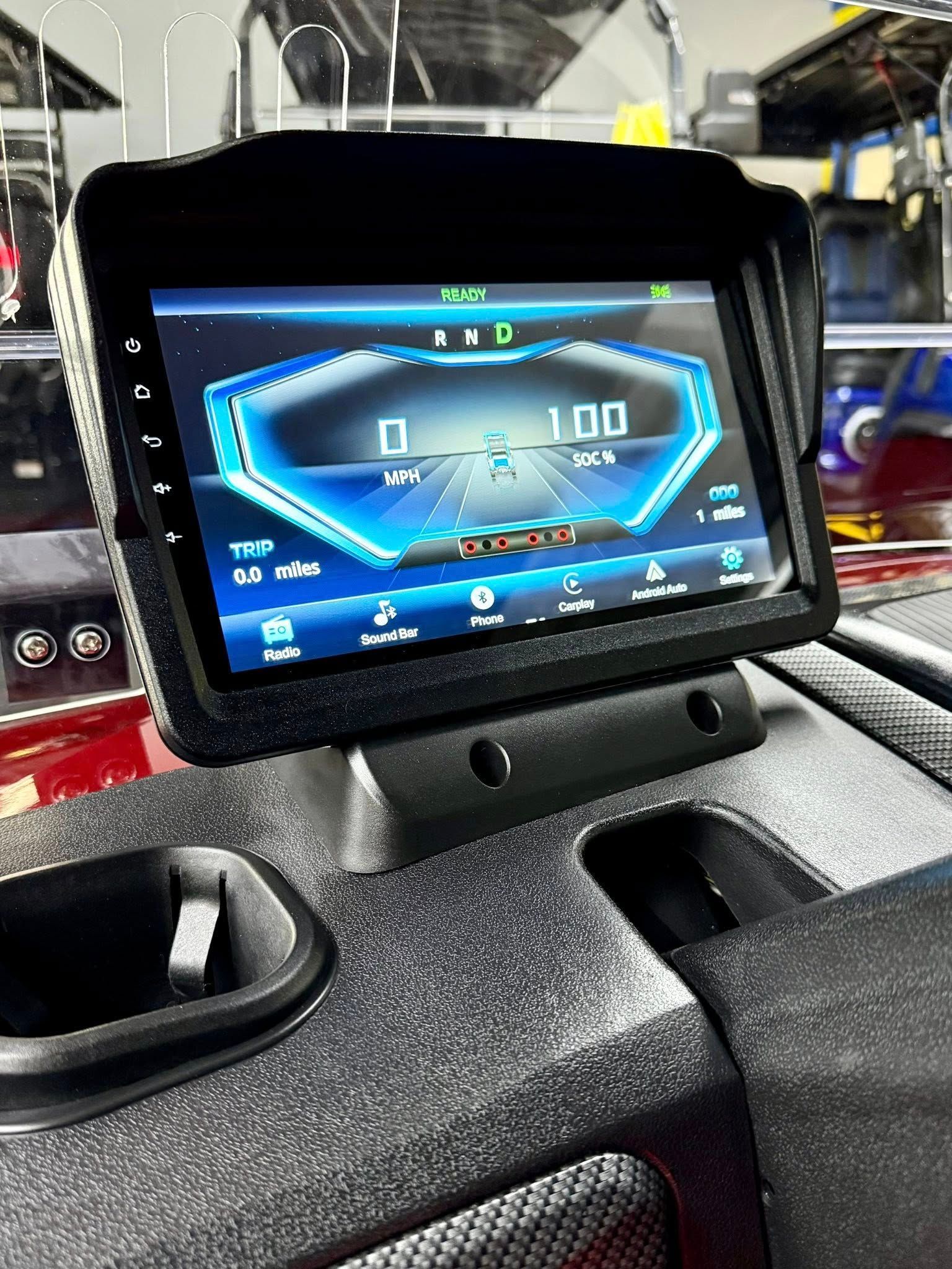 Dashboard with a digital display showing speedometer and gauges, mounted on a textured console with a cup holder.